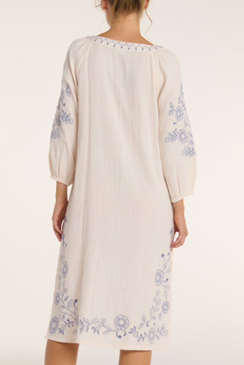 Beige dress with floral embroidery on a white background