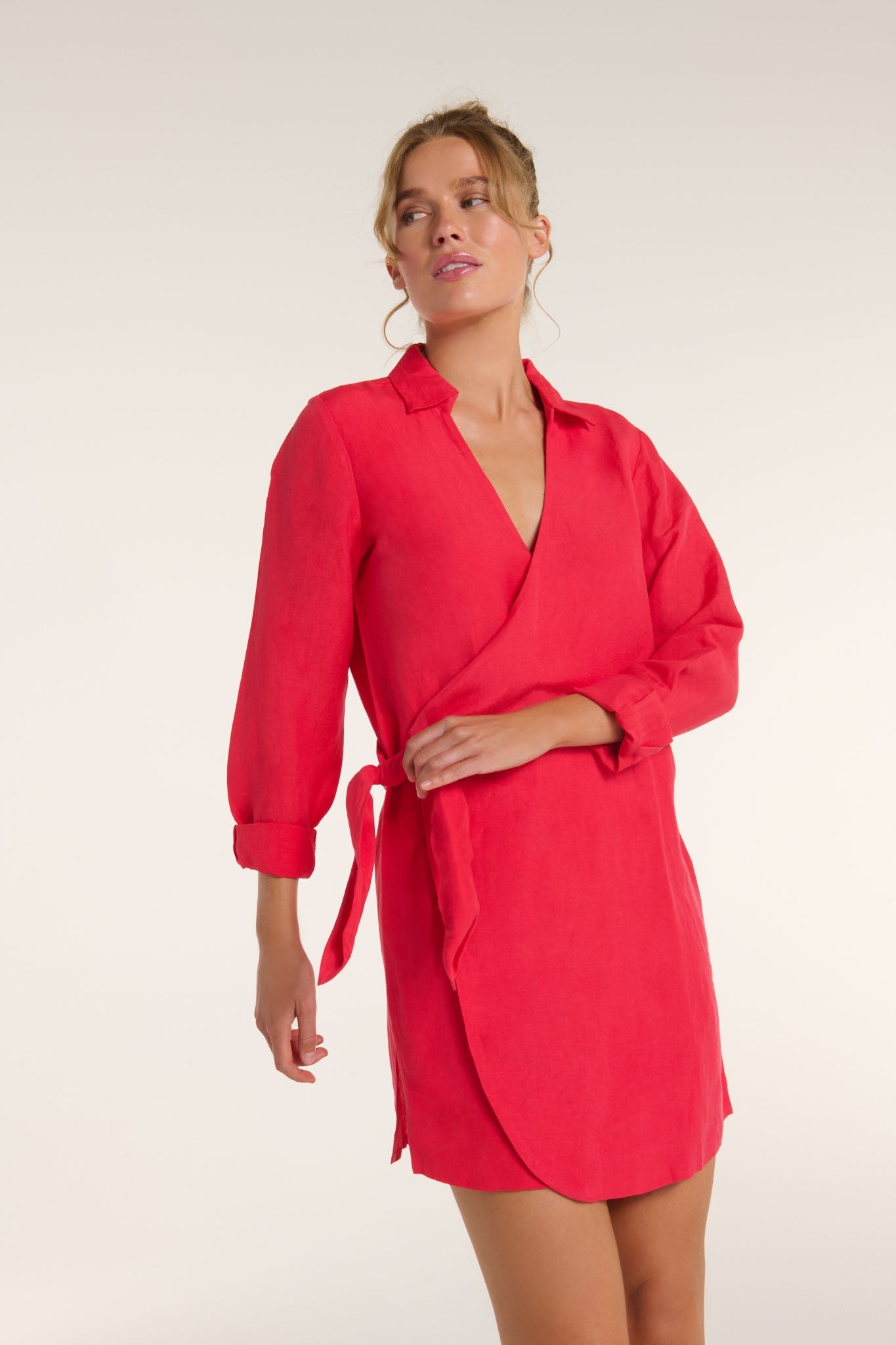 Woman wearing a red dress with a belt on a white background