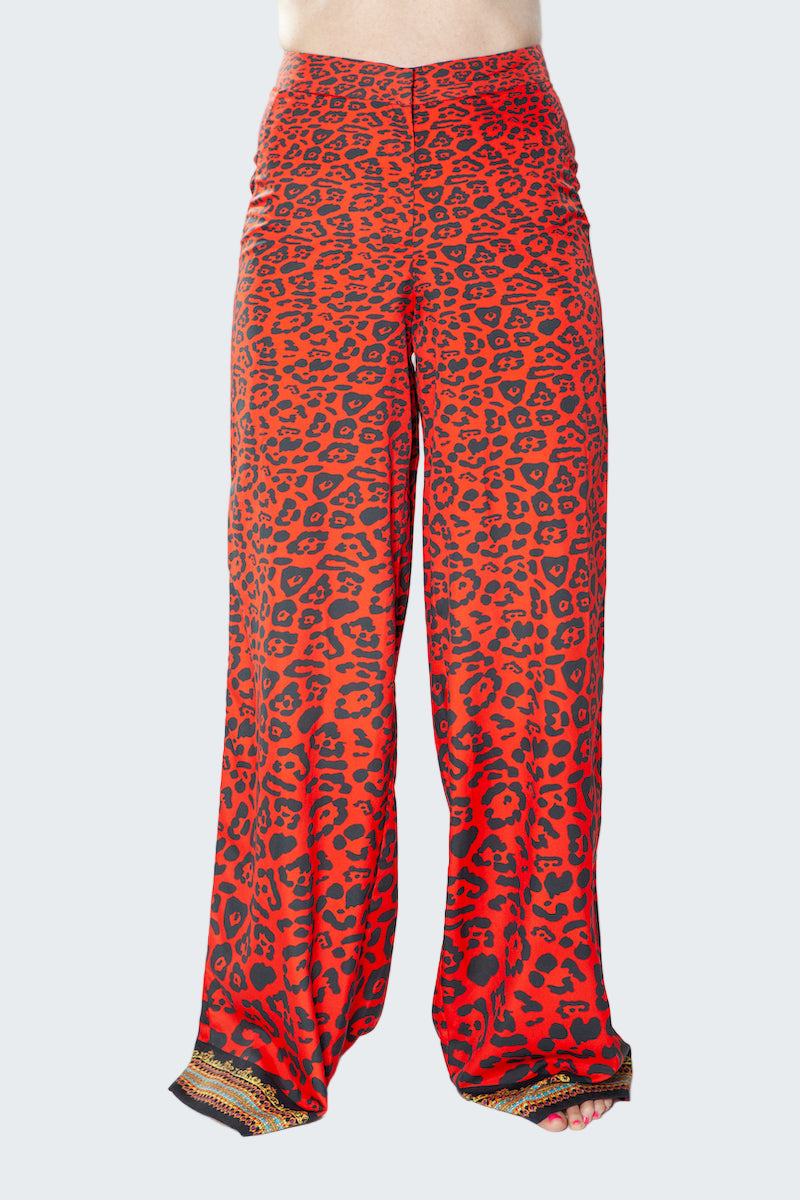 Red leopard print pants with gold trim on a white background