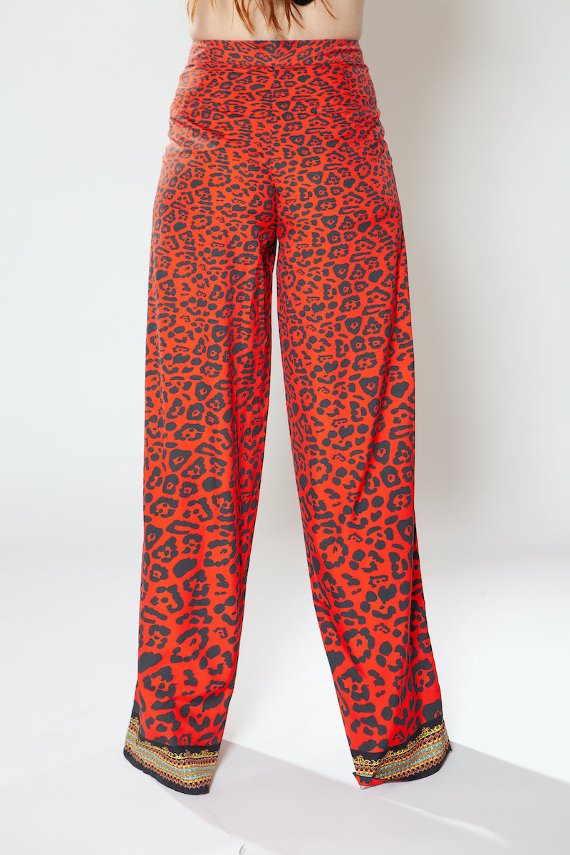 Red leopard print pants with gold trim on a white background