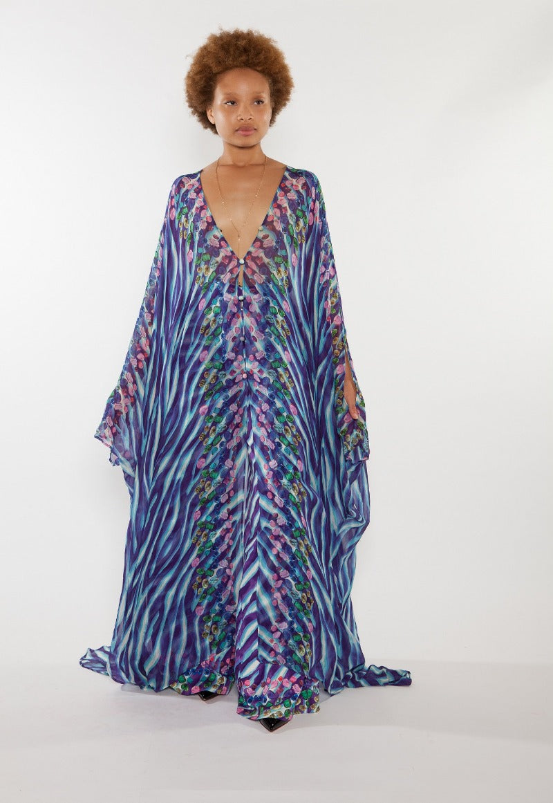 Woman wearing a long, patterned dress with a white background