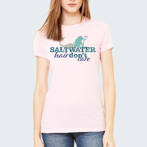 Person wearing a pink t-shirt with a mermaid graphic and text on a white background