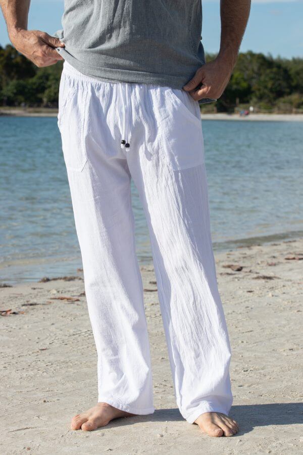 Person wearing white pants and a gray shirt on a beach.
