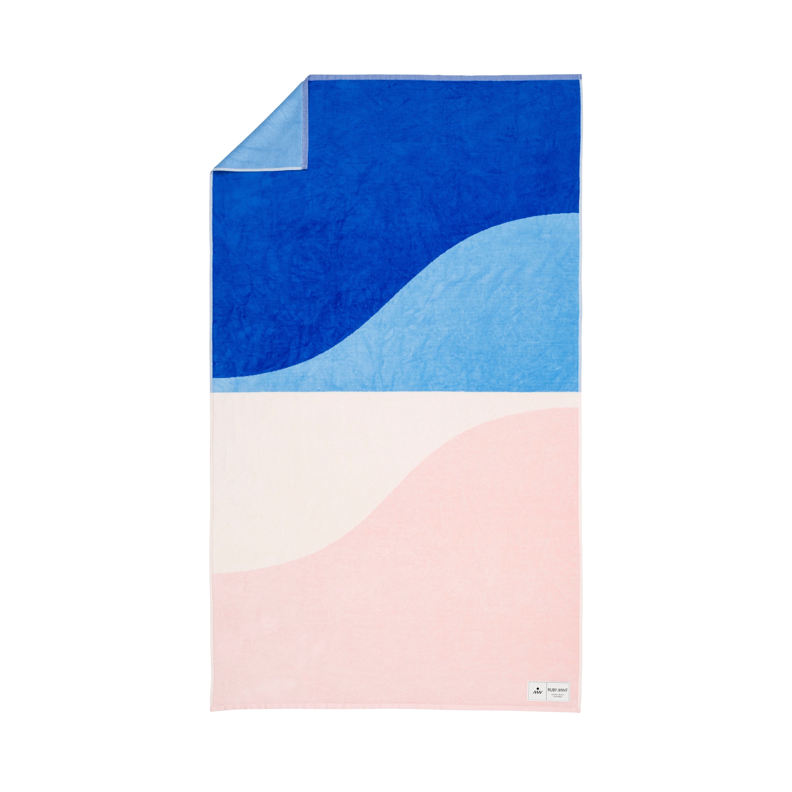 Color-blocked towel with blue, pink, and white design on a white background