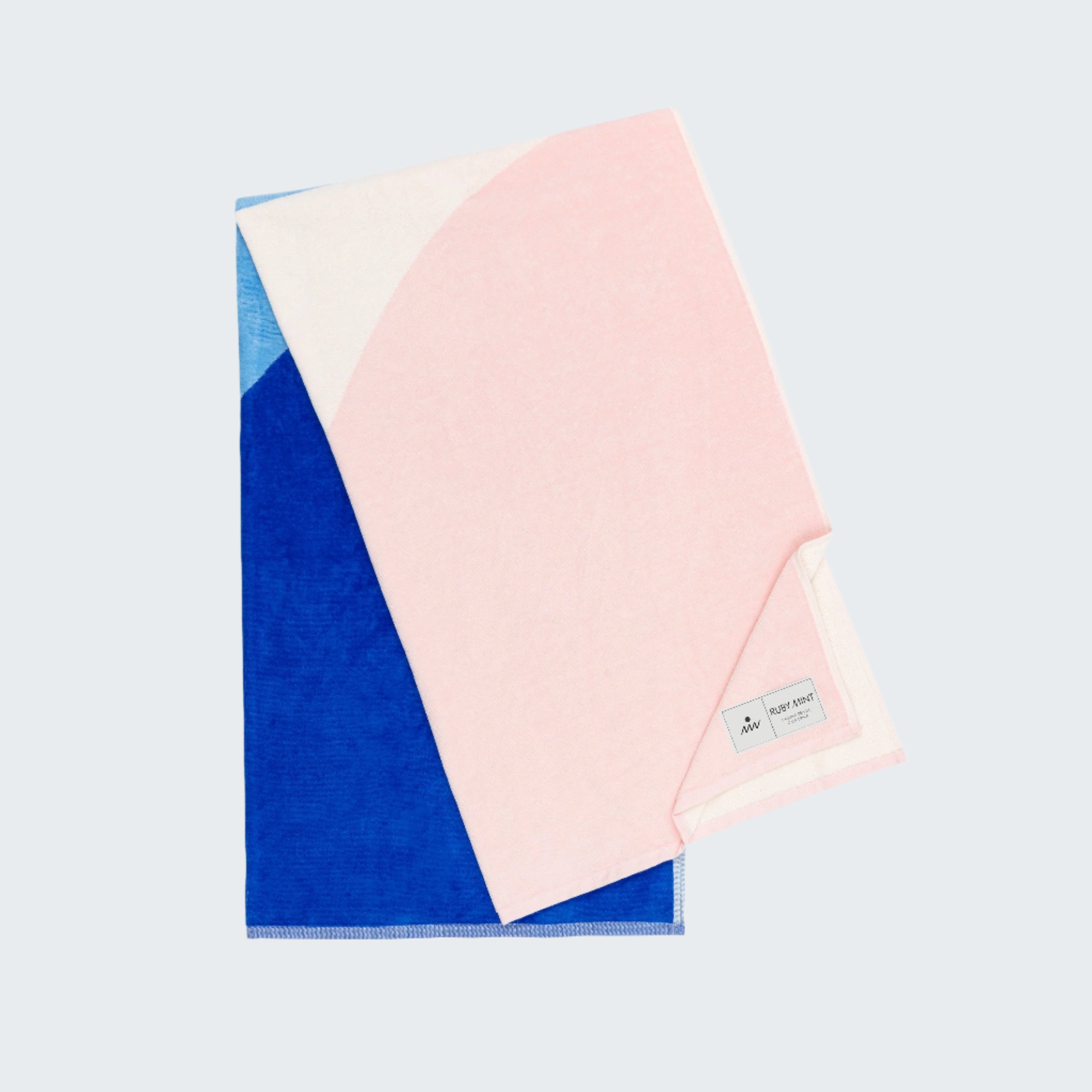 Color-blocked towel with pink, blue, and white sections on a white background