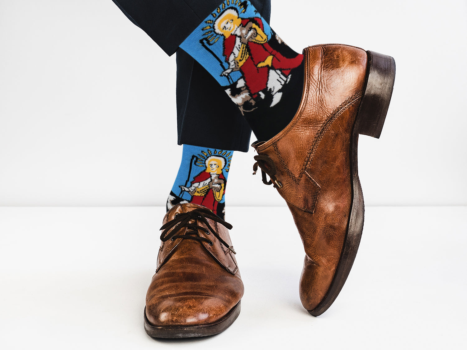 Brown leather shoes with colorful socks featuring cartoon characters on a white background