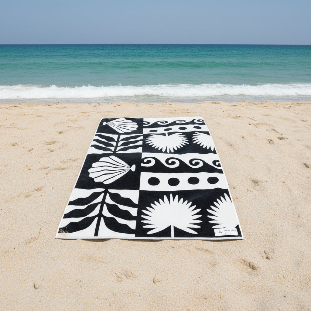 Black and white patterned towel with geometric and natural designs on a white background