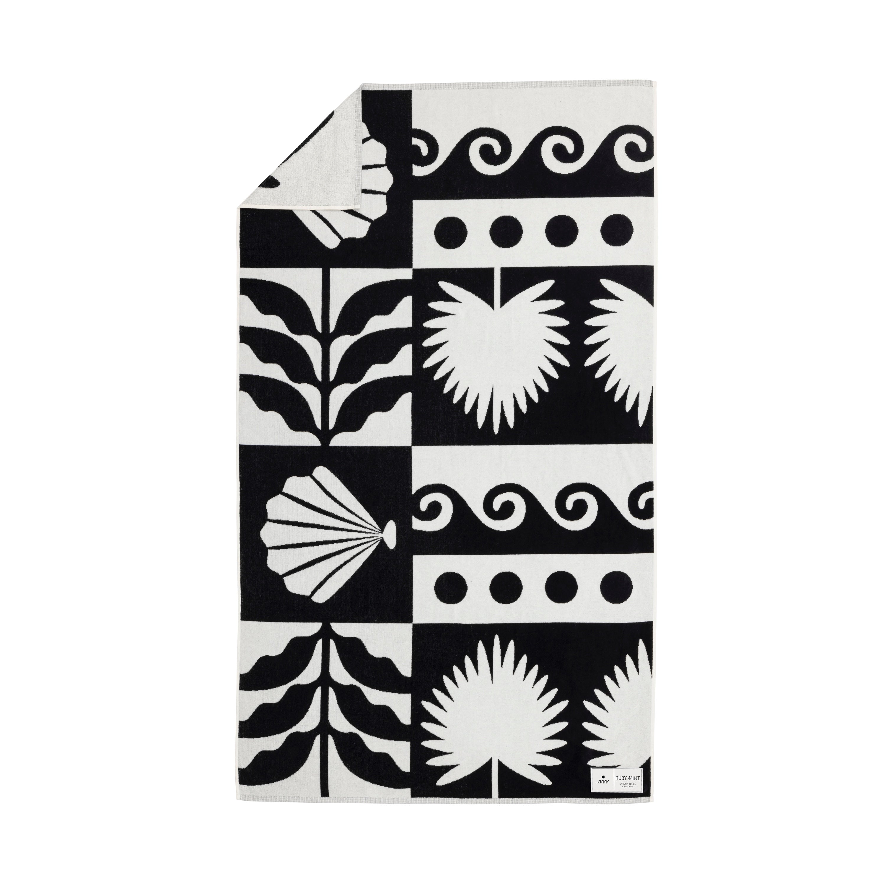 Black and white patterned towel with geometric and natural designs on a white background