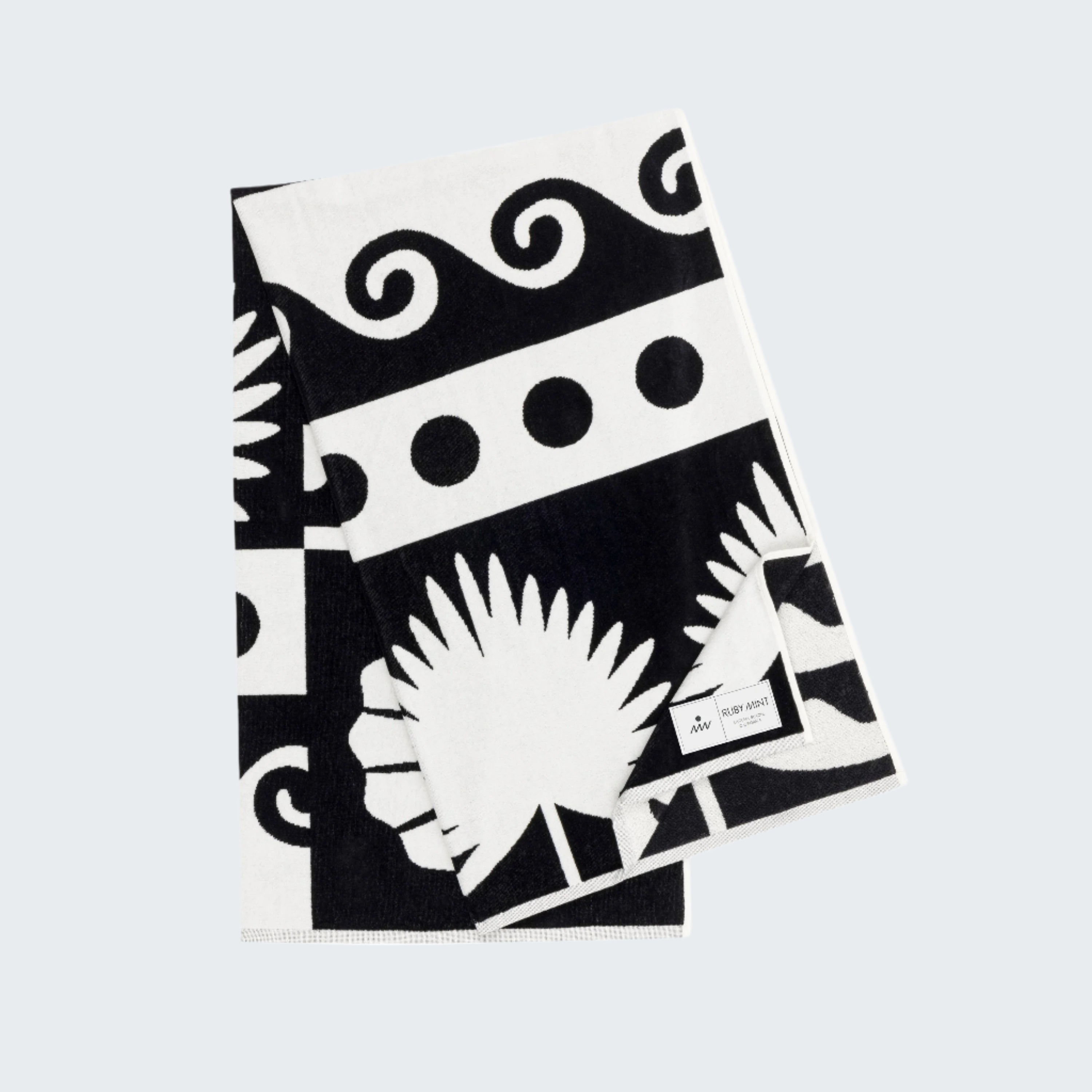 Black and white patterned towel with palm leaf design on a white background