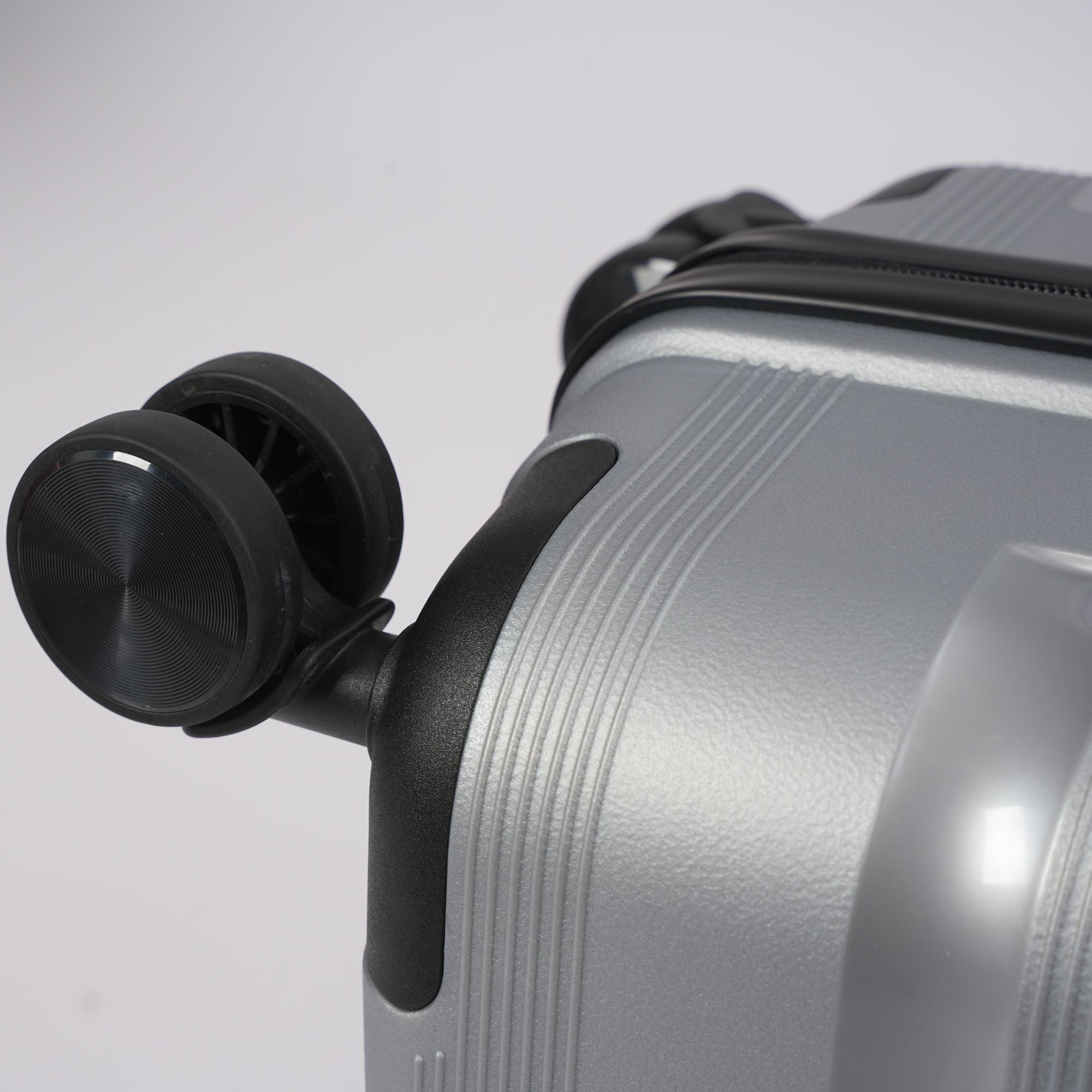 Silver suitcase with black handle on a light gray background