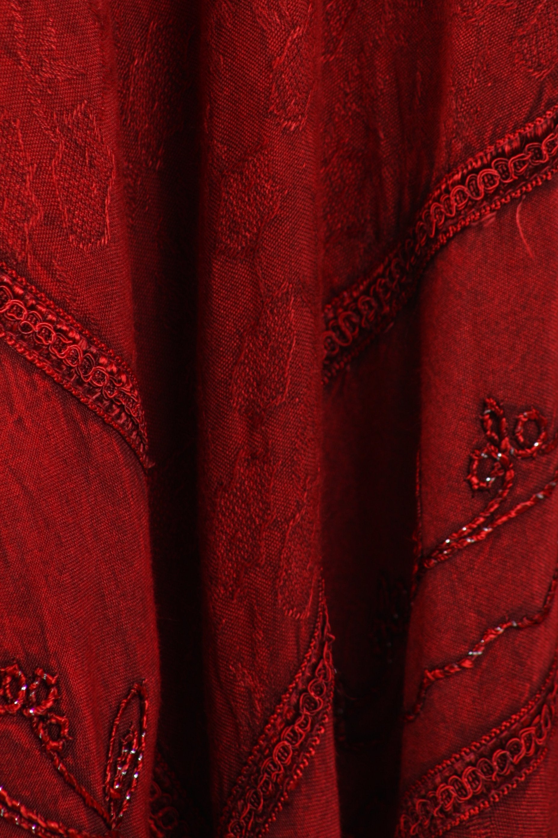 Close-up of red fabric with intricate patterns and embroidery