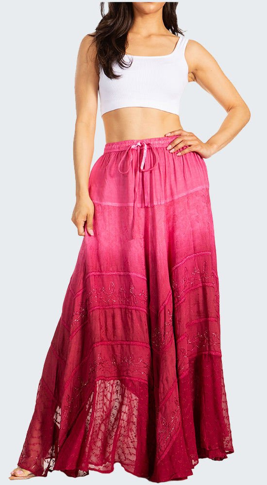 Woman wearing a white crop top and pink long skirt on a white background