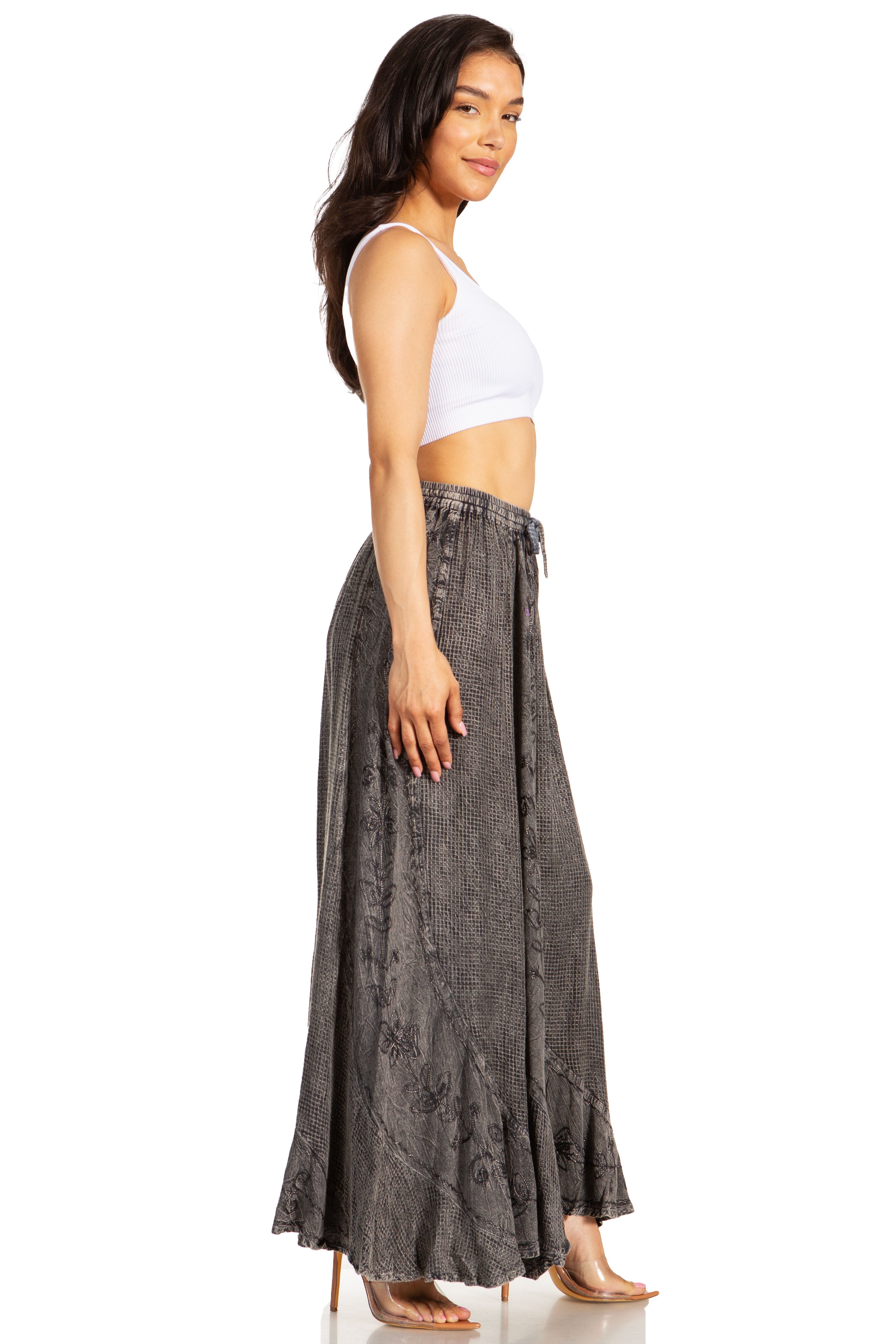 Woman wearing a white tank top and gray floral skirt on a white background