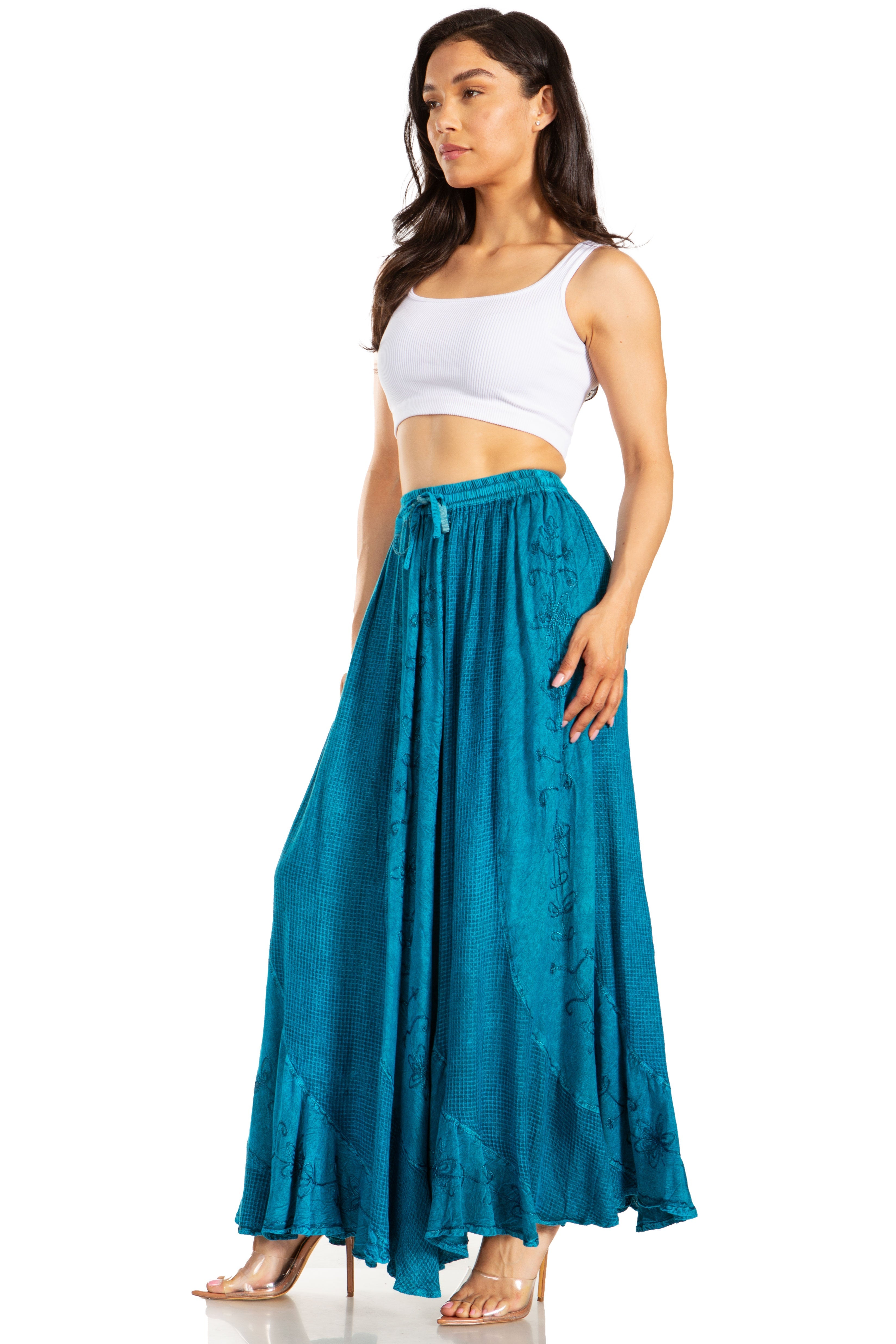 Woman wearing a white top and teal skirt on a white background