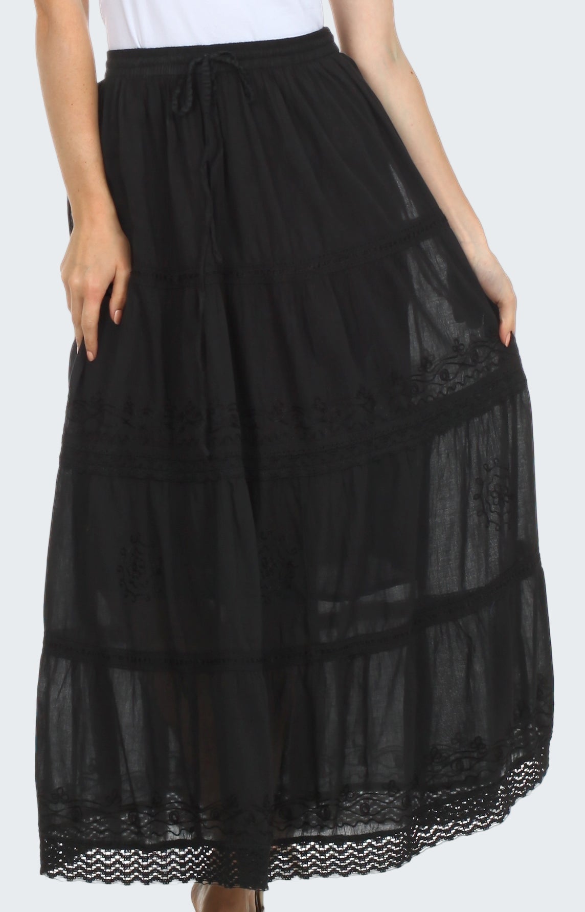 Black lace-trimmed skirt worn by a person on a white background