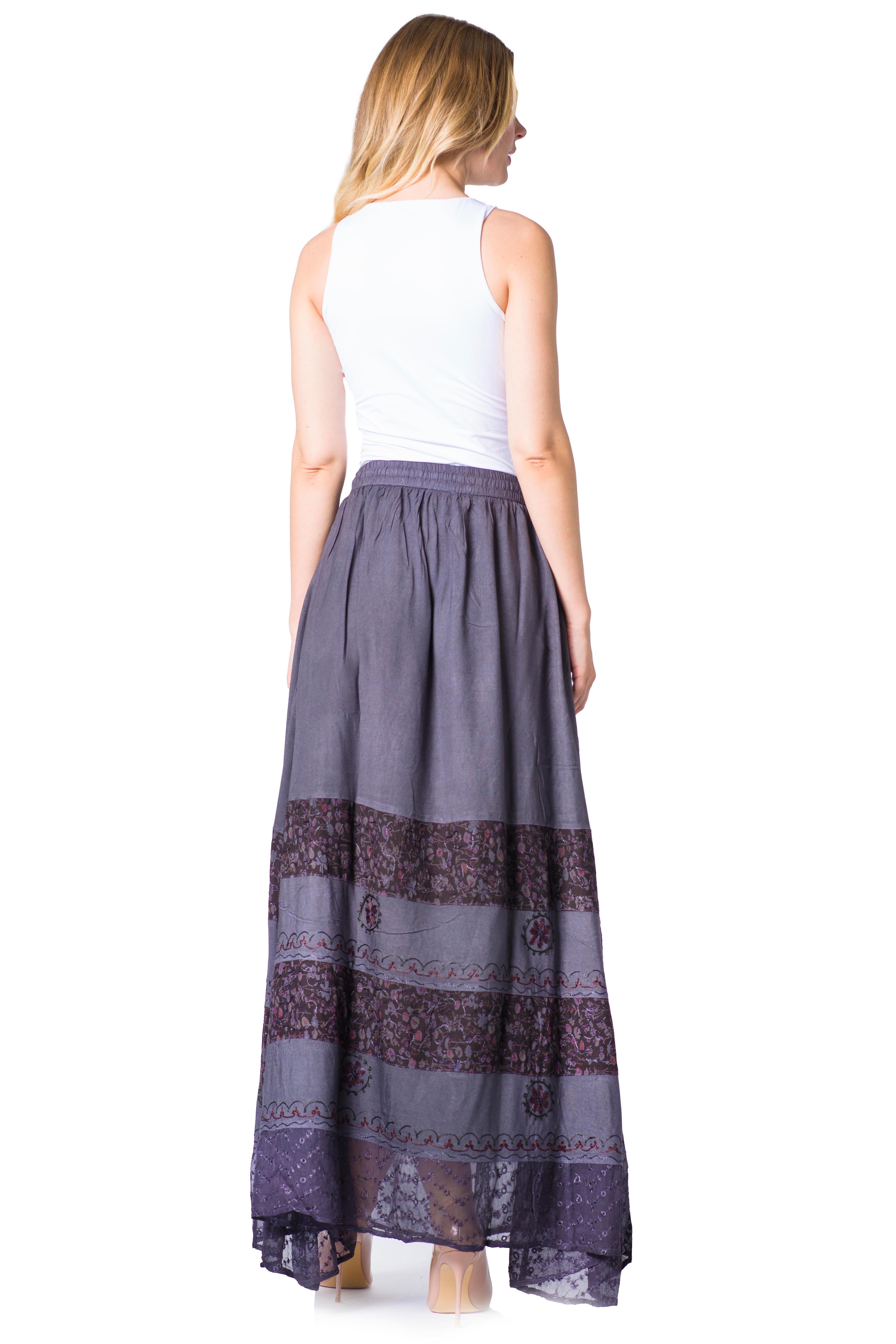 Woman wearing a long, patterned skirt with a white top on a white background