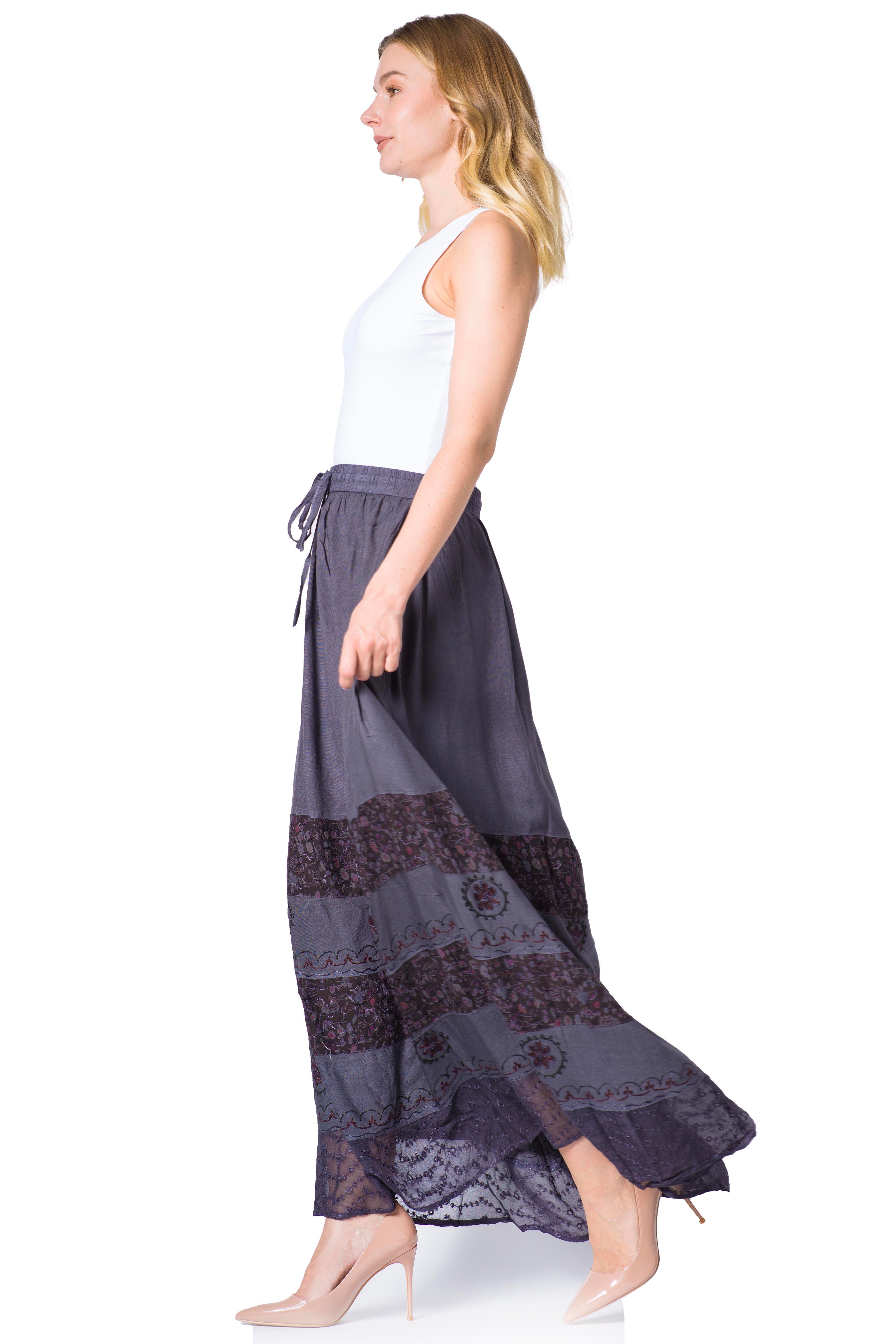 Woman wearing a long, dark gray skirt with lace details on a white background