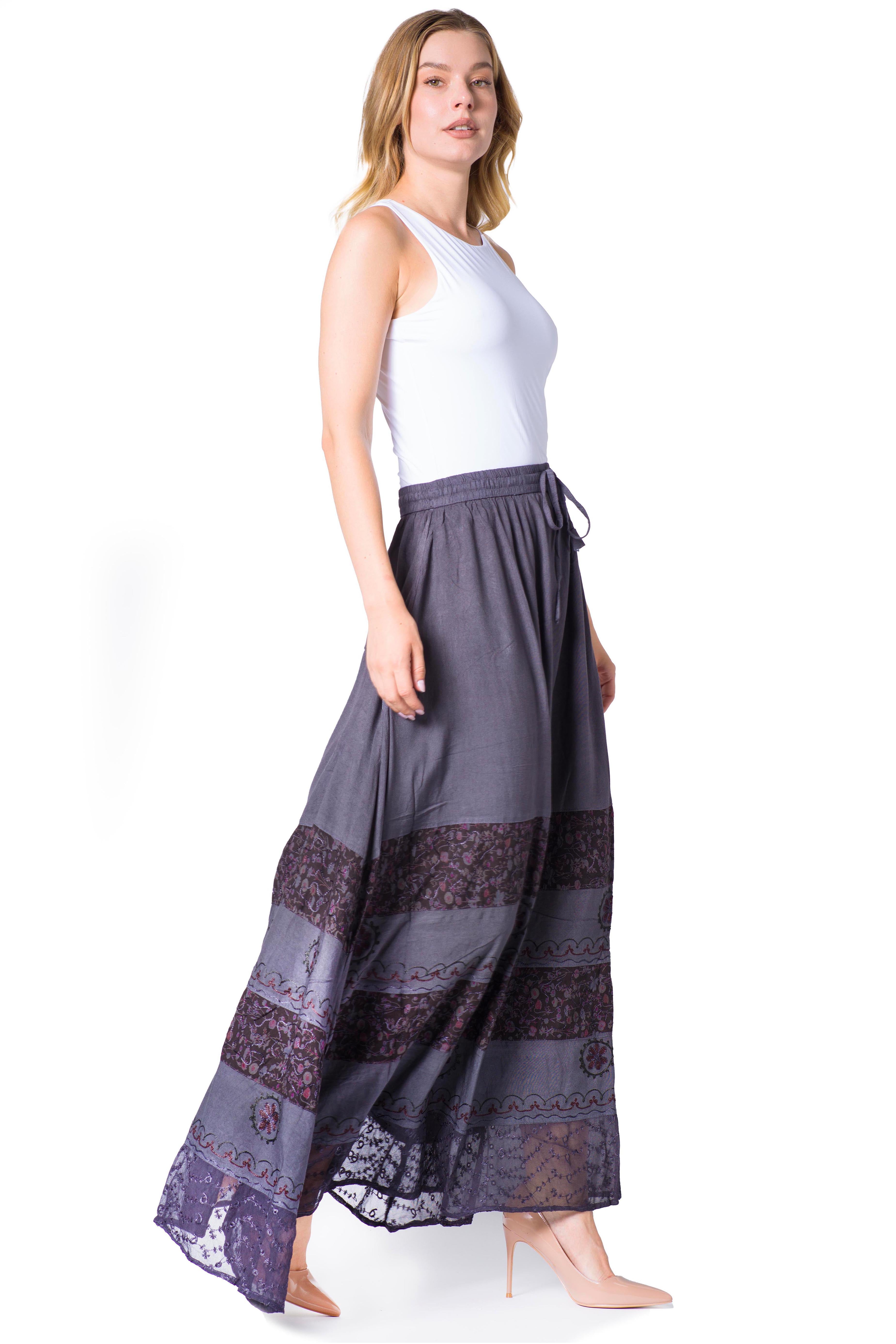 Woman wearing a long, dark gray skirt with lace details on a white background