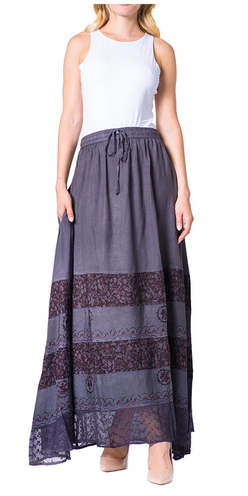 Woman wearing a long, patterned skirt with a plain background