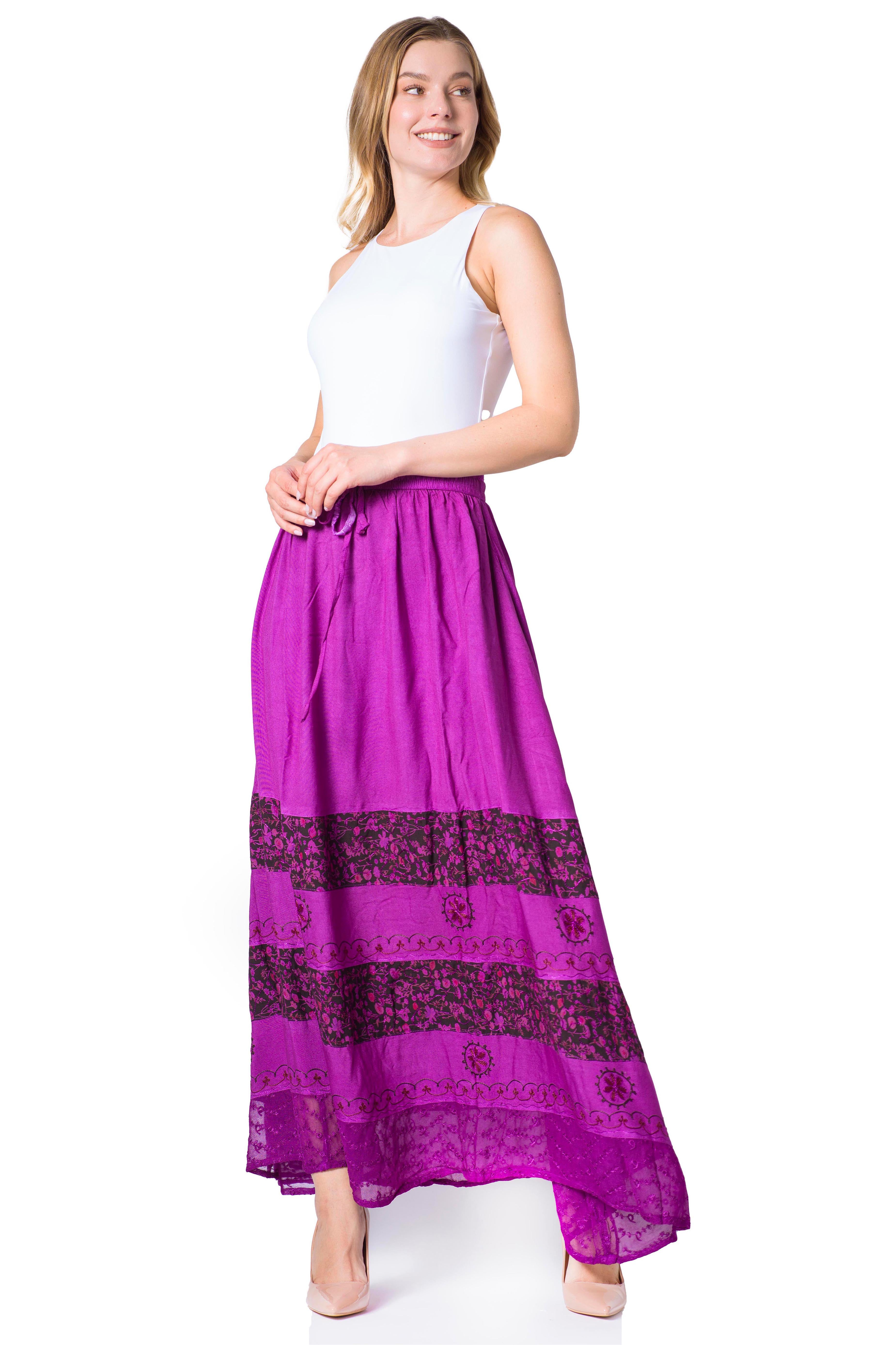 Woman wearing a white top and purple skirt with black patterns on a white background