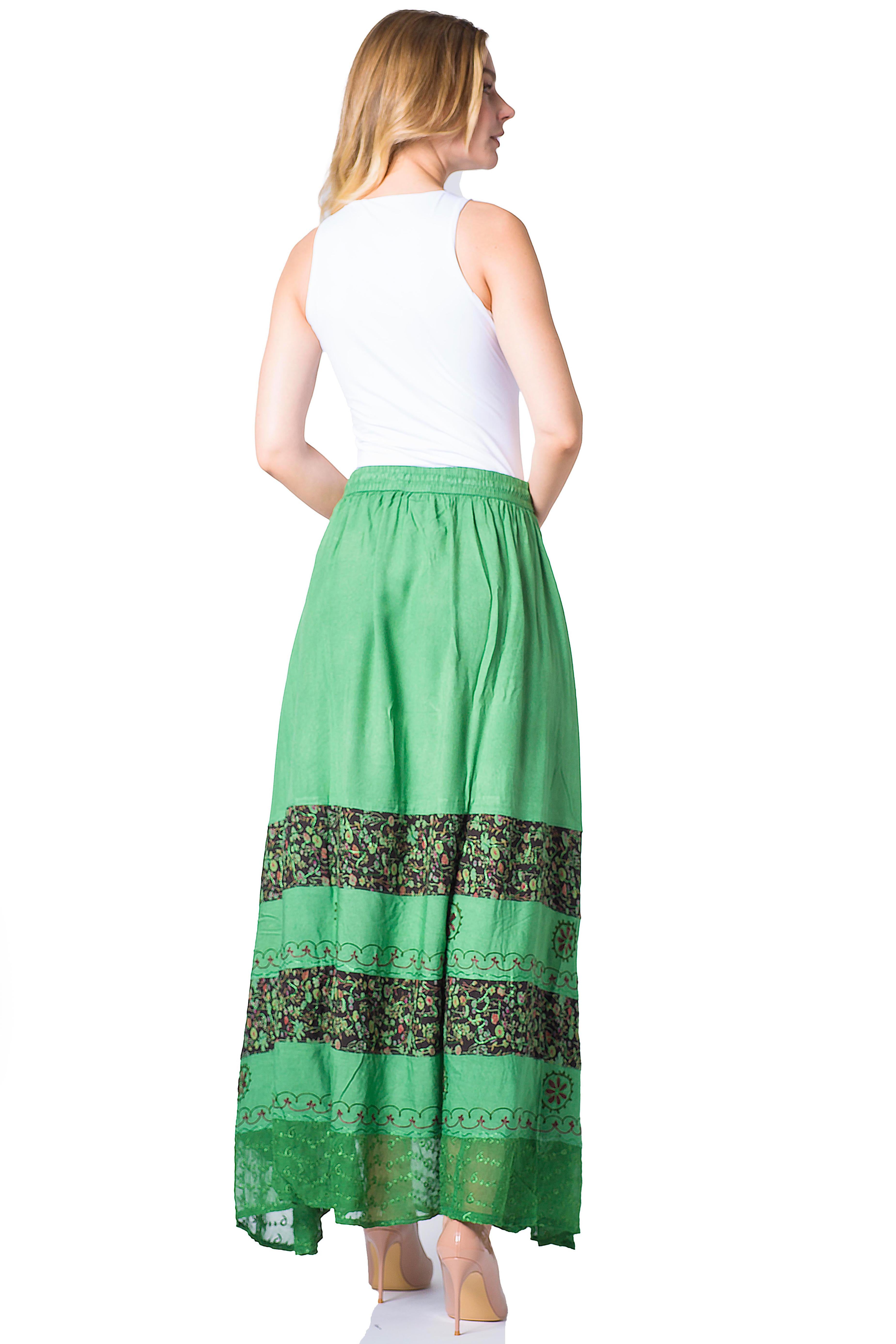 Woman wearing a green skirt with a floral pattern on a white background