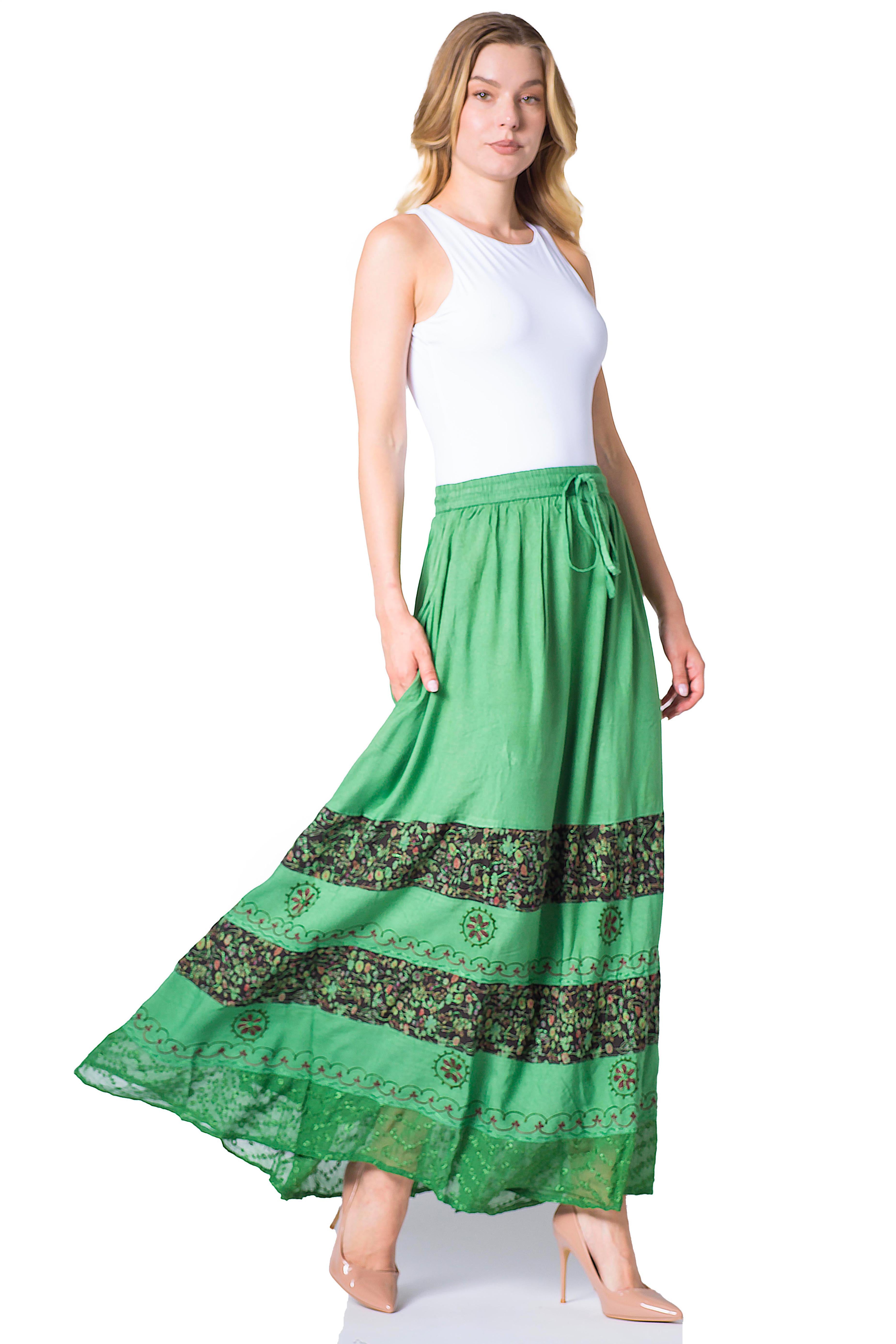 Woman wearing a green long skirt with a white top on a white background