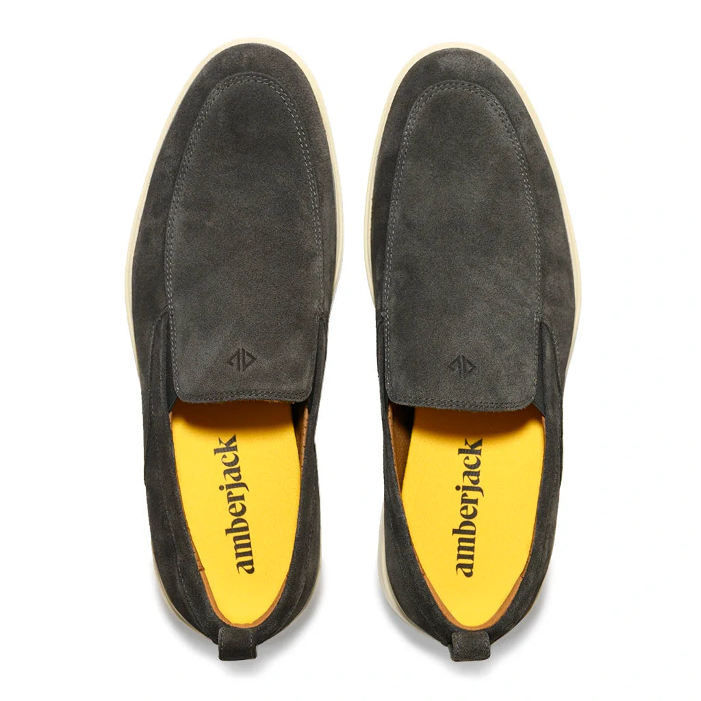 Pair of gray suede shoes with yellow insole on a white background
