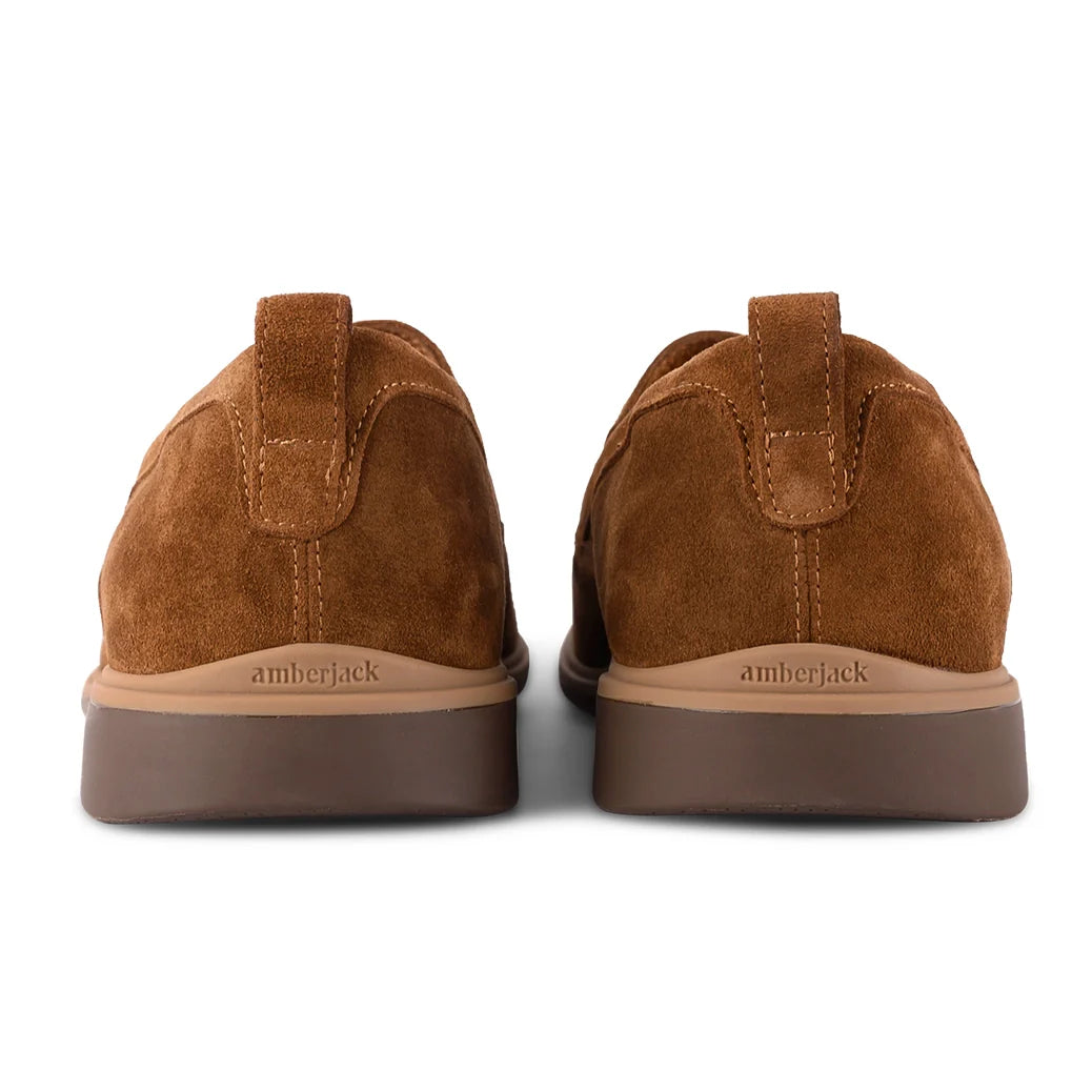 Brown suede shoes with 'amberjack' branding on a white background