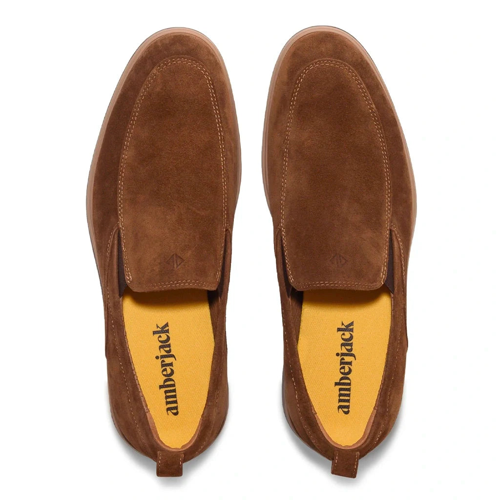 Pair of brown suede loafers with 'amberjack' branding on a white background