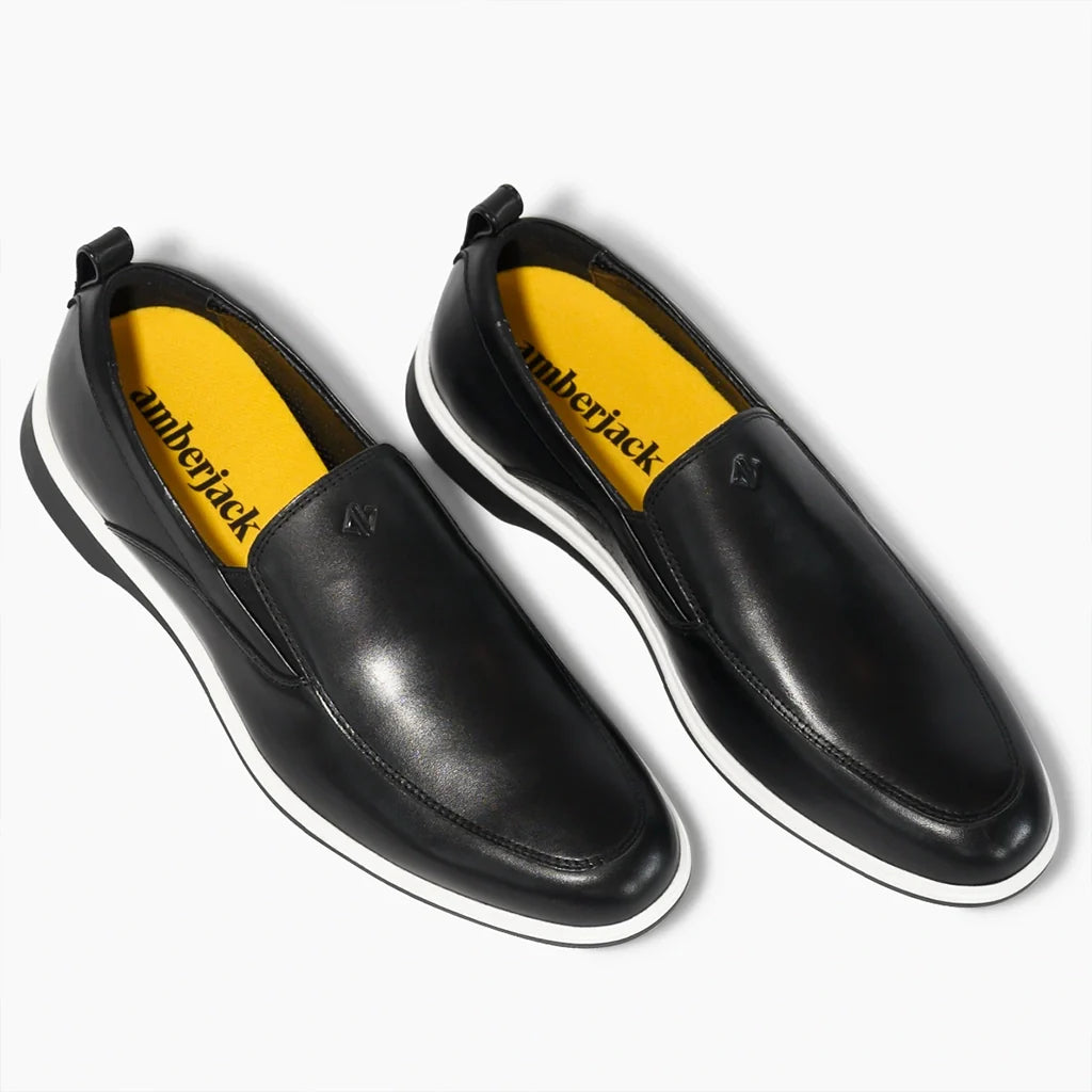 Black slip-on shoes with yellow interior and 'umbrojack' branding on a white background