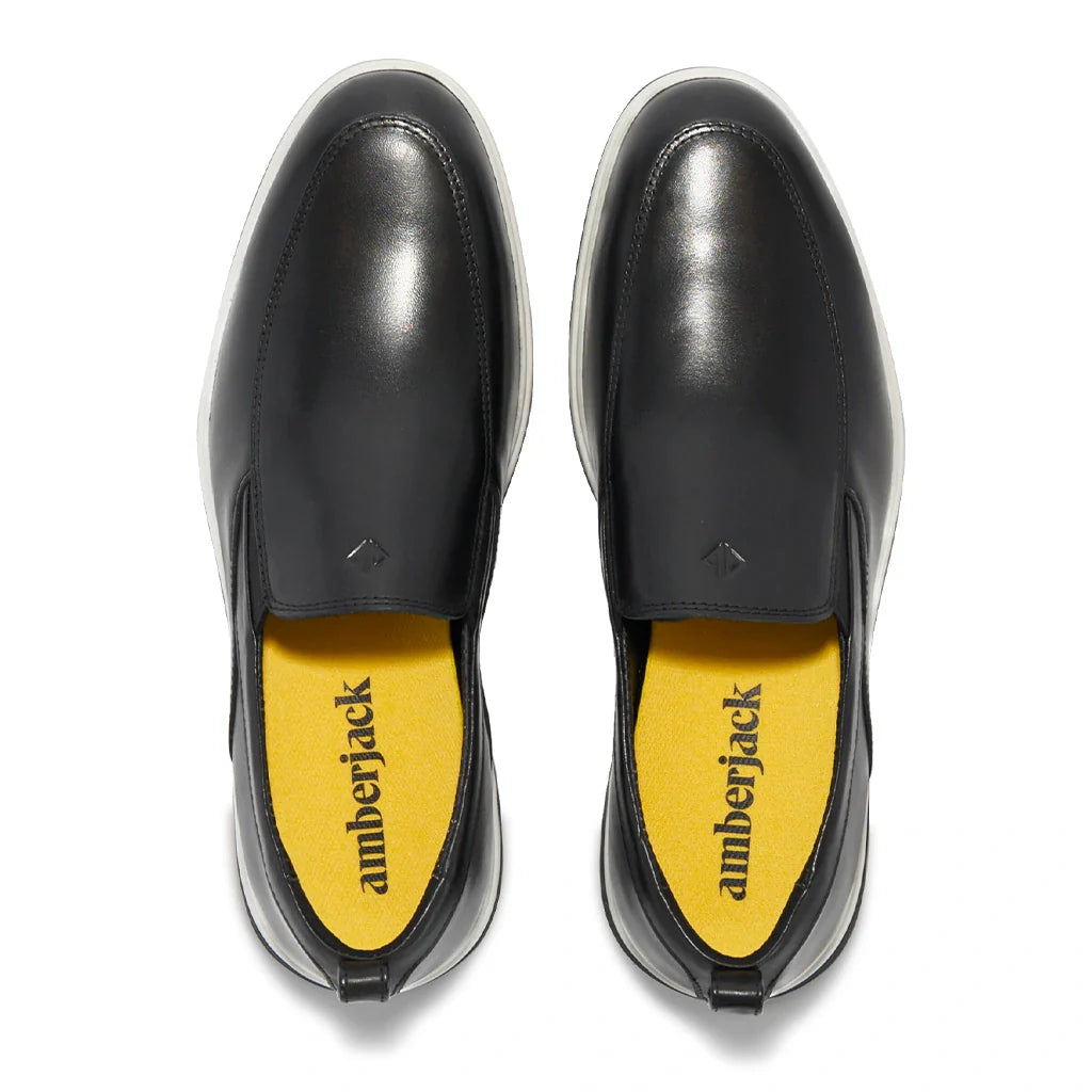 Black leather shoes with yellow insole displaying 'amberjack' brand on a white background