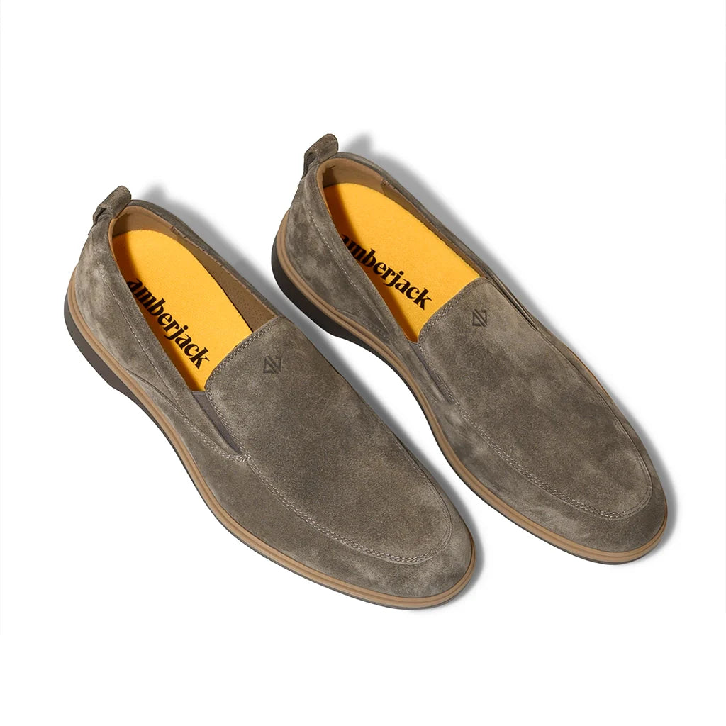 Pair of brown suede shoes with yellow interior on a white background