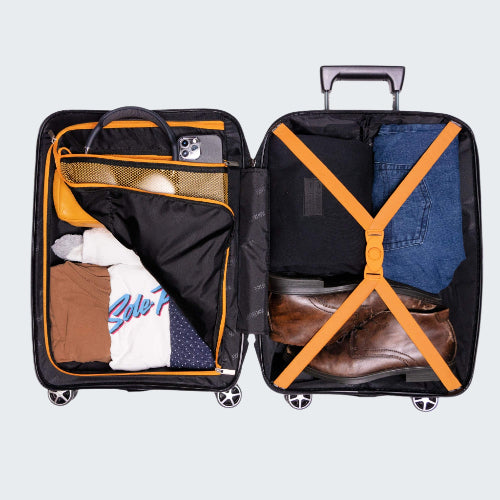 Open suitcase with clothes and items inside on a white background