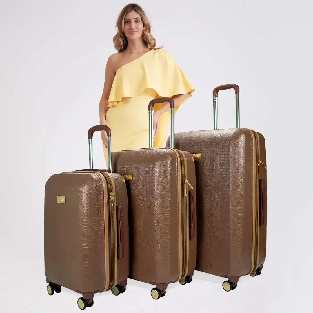 Woman in a yellow dress standing next to three brown suitcases on a white background