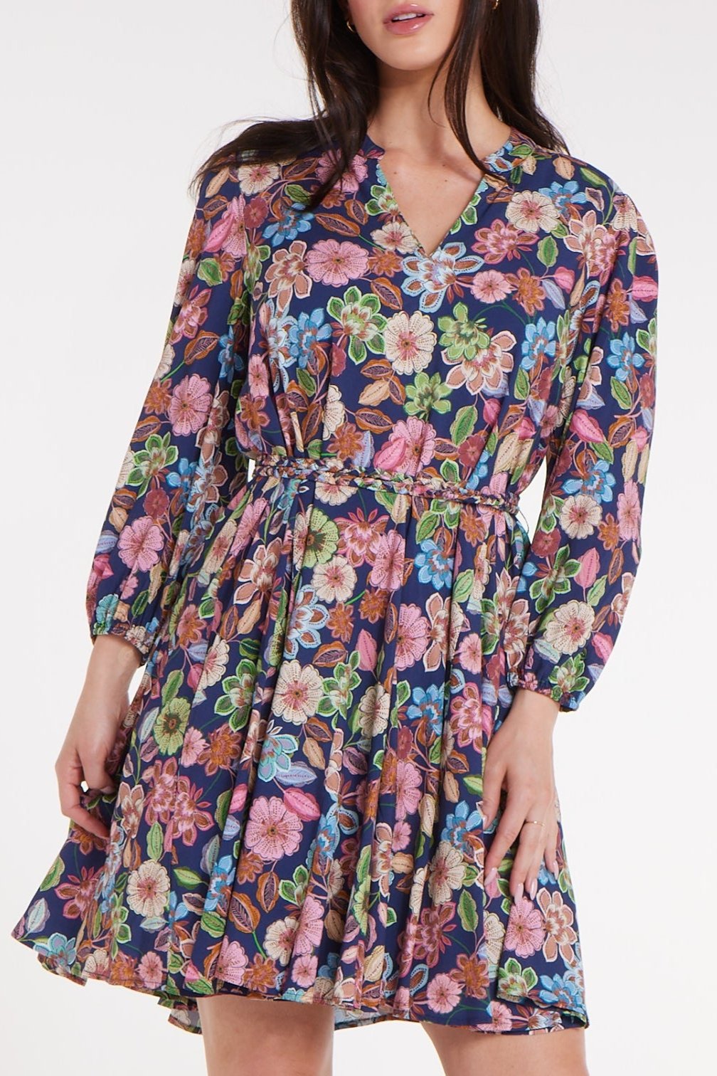 Woman wearing a floral dress with long sleeves on a white background