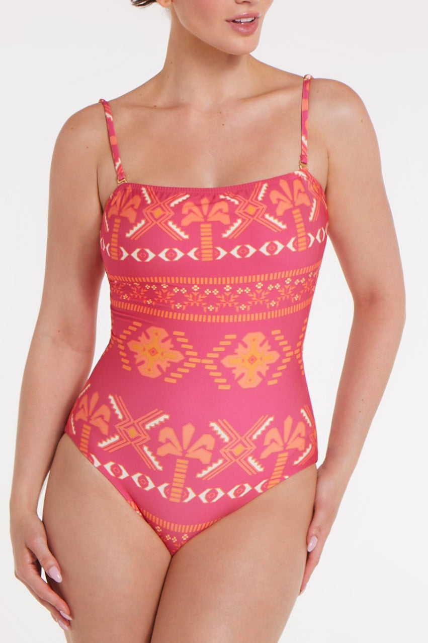 Woman wearing a pink and orange patterned swimsuit on a white background