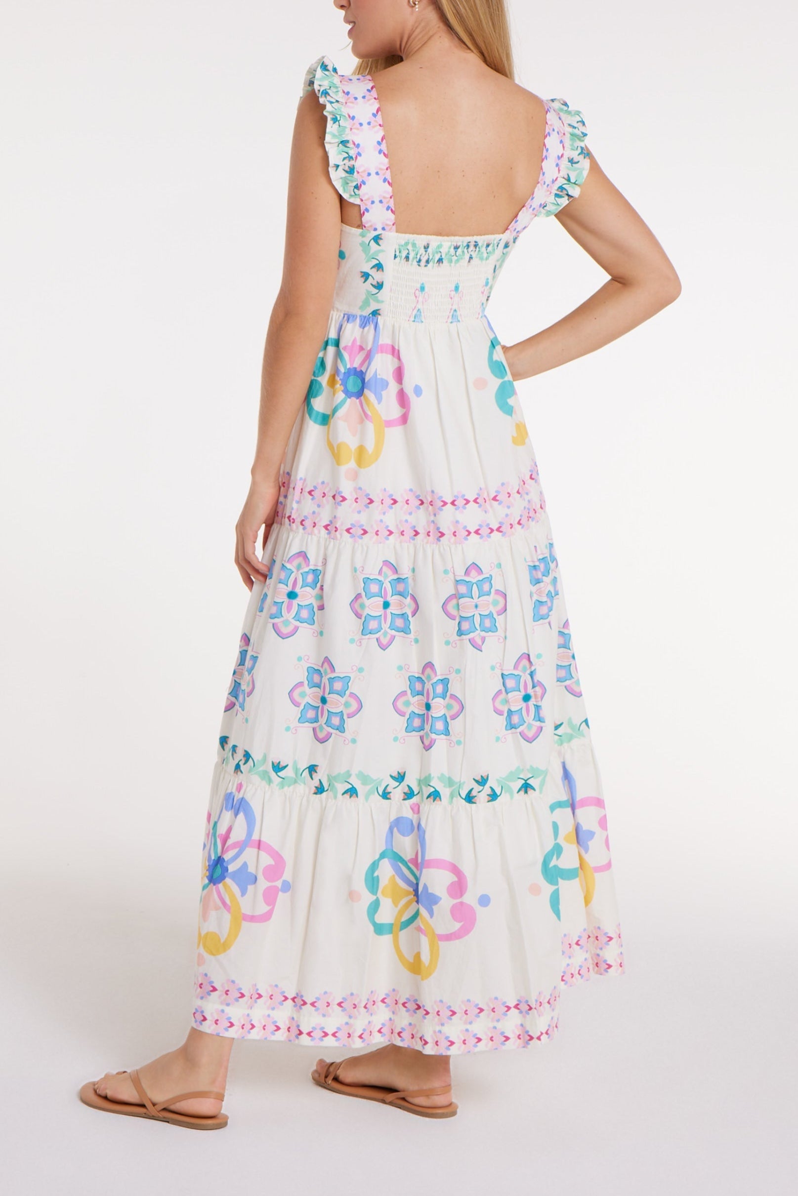 Woman wearing a floral embroidered dress on a white background