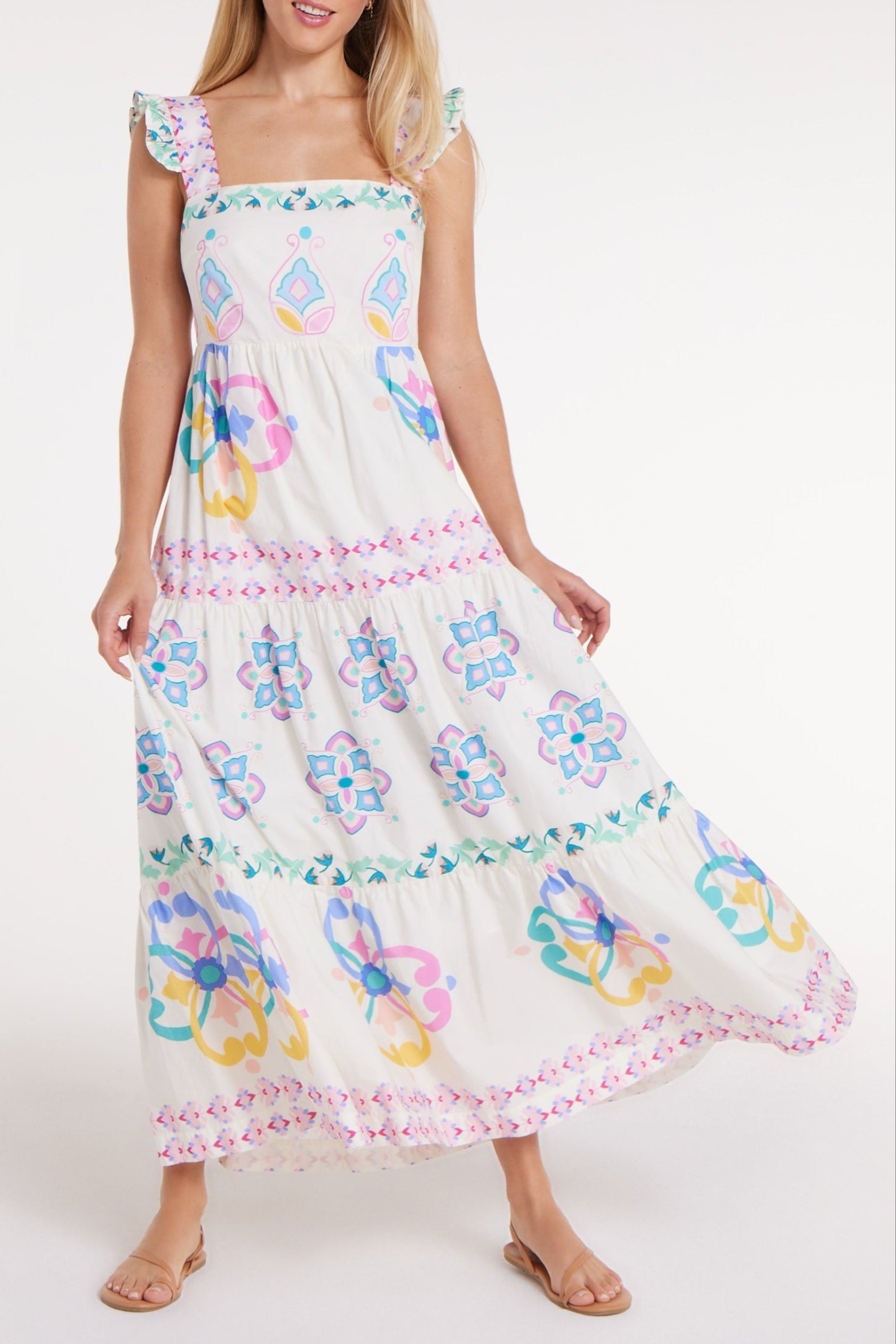 Woman wearing a white dress with colorful floral patterns on a white background