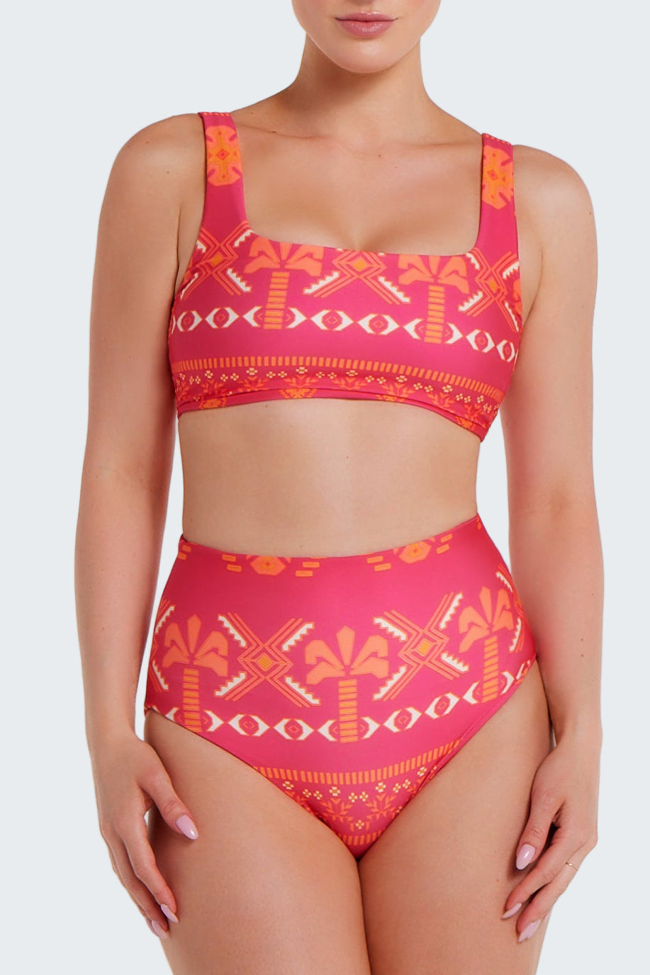 Woman wearing a red and orange patterned bikini set on a white background