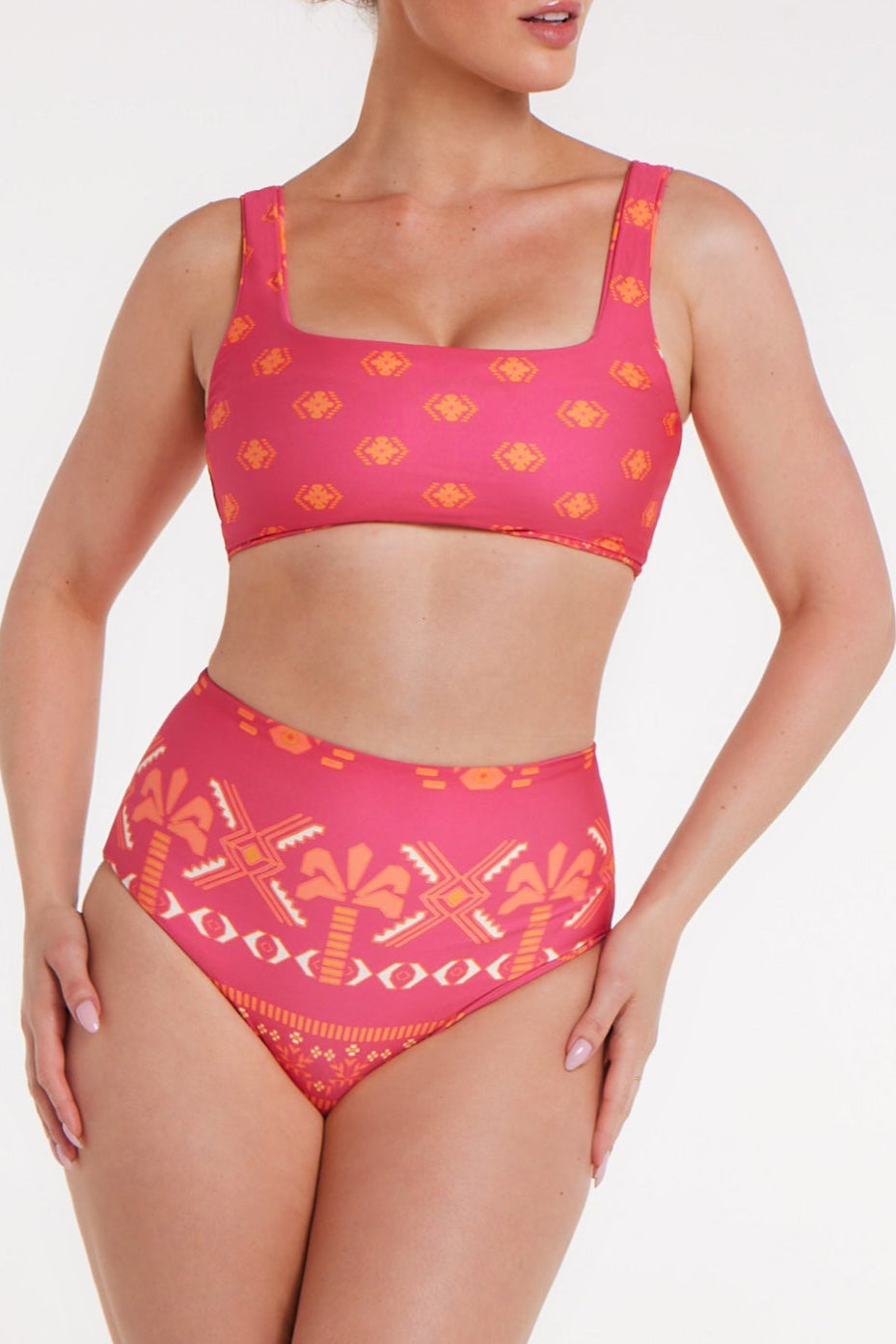 Woman wearing a pink bikini with a geometric pattern on a white background