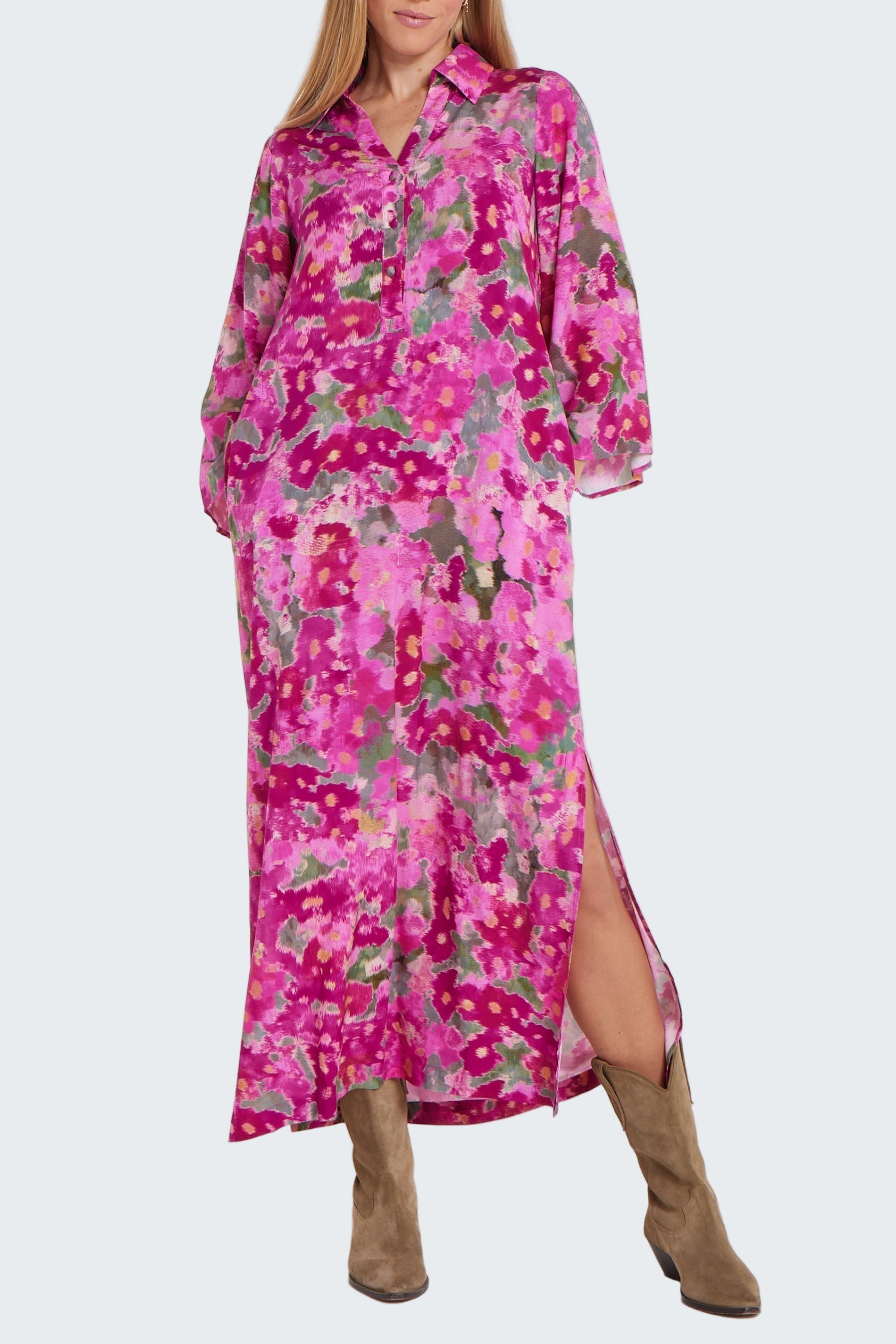Woman wearing a pink floral dress with long sleeves on a white background