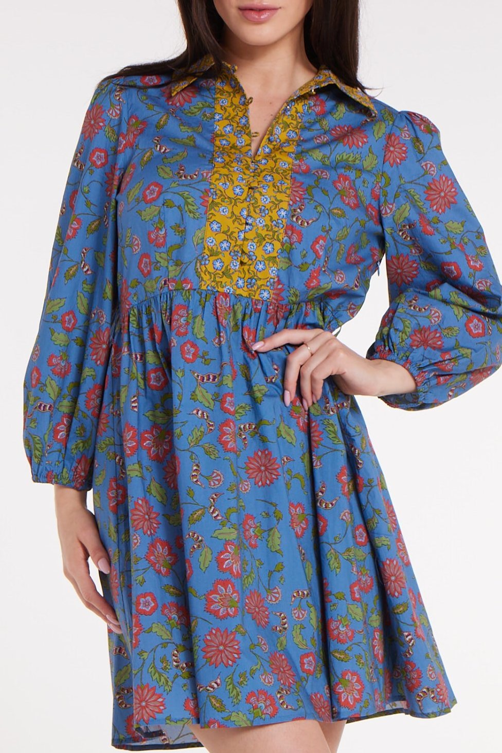 Woman wearing a blue floral dress with a white background