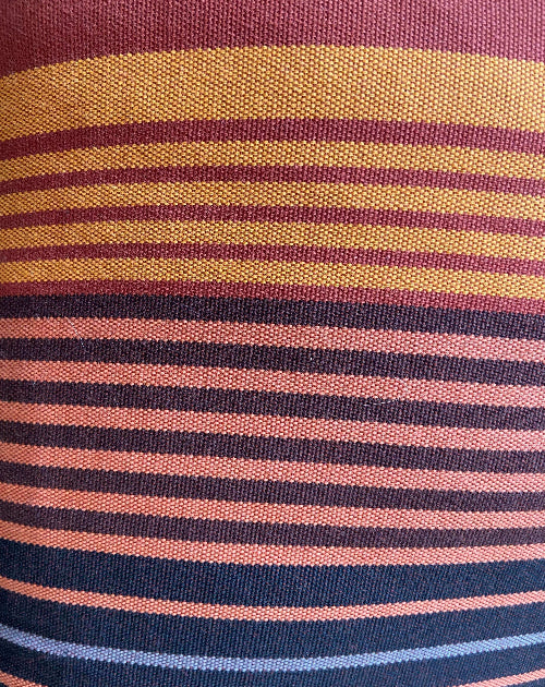 Close-up of fabric with multicolored stripes in red, yellow, blue, and pink.