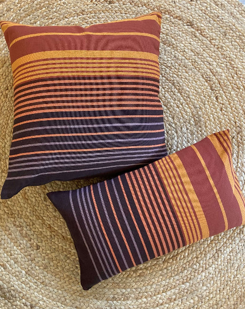 Two striped pillows on a textured surface
