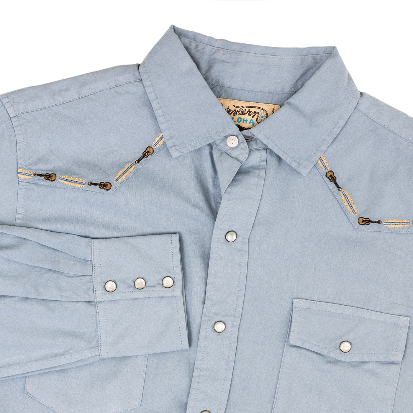 Light blue shirt with zippers and buttons on a white background