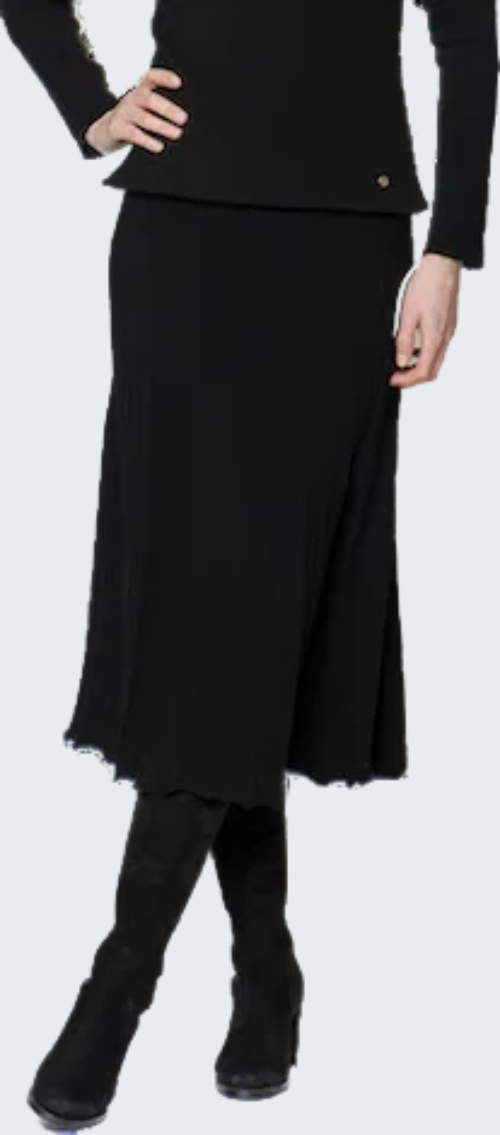 Person wearing a black outfit with a skirt and boots on a white background