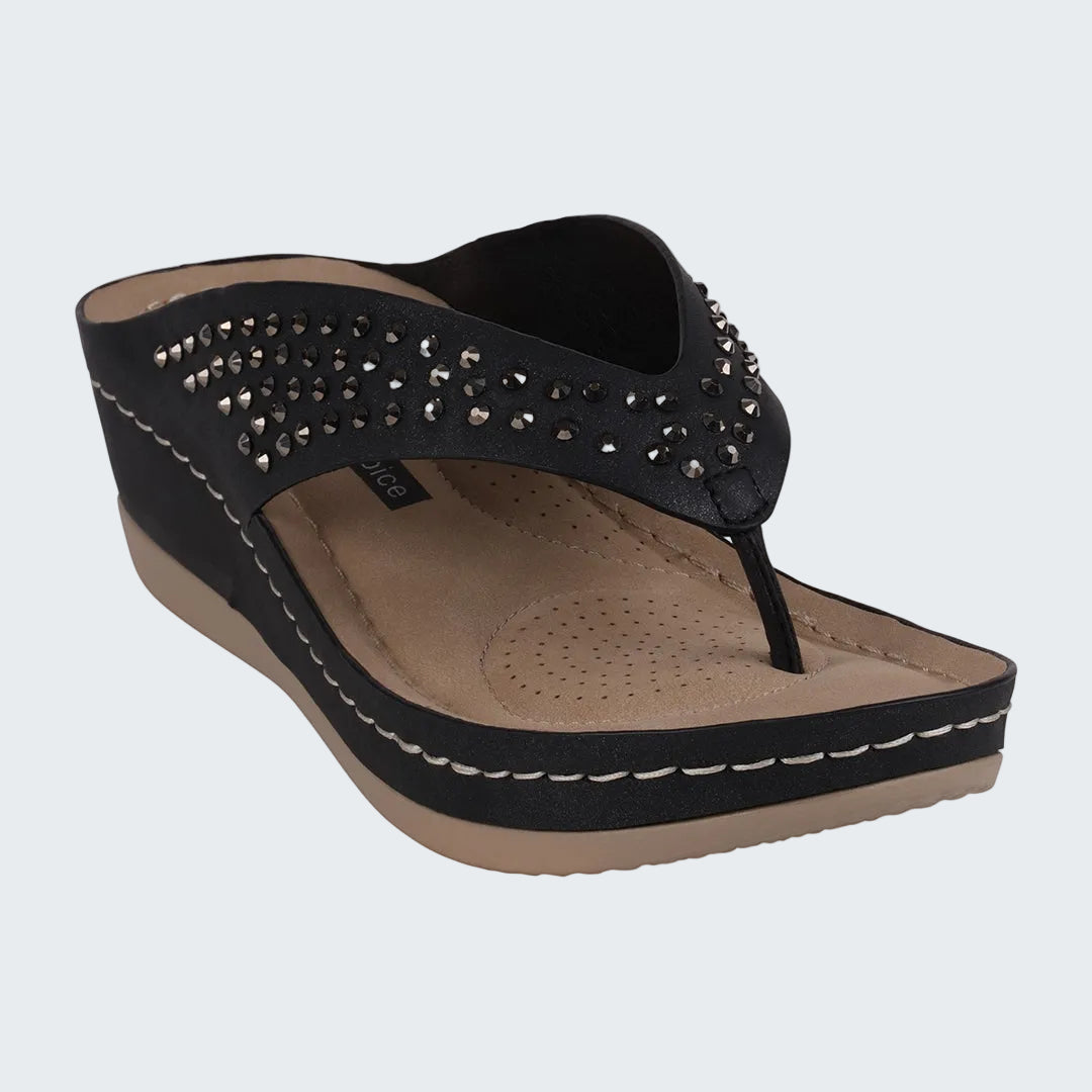 Black sandal with studded details on a white background