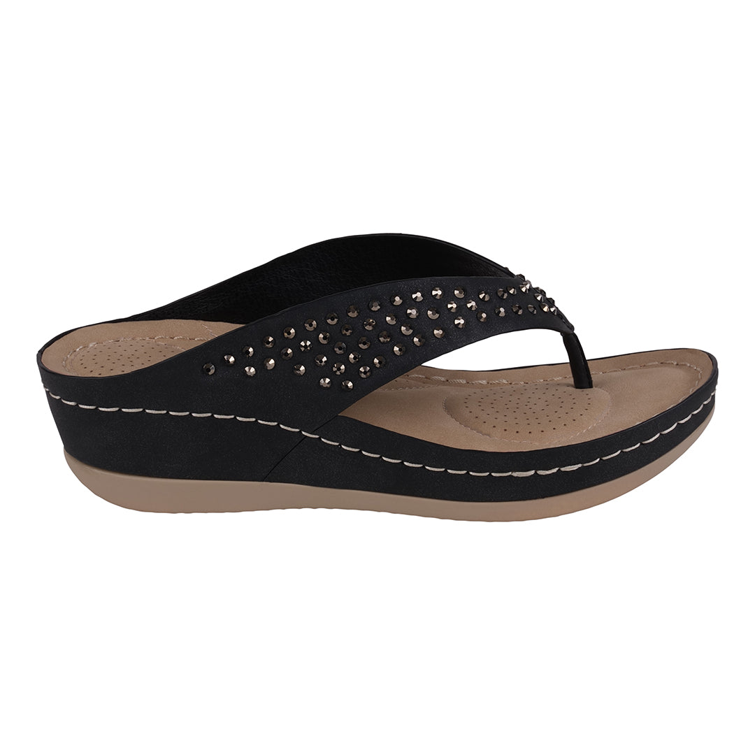 Black wedge sandal with studded details on a white background