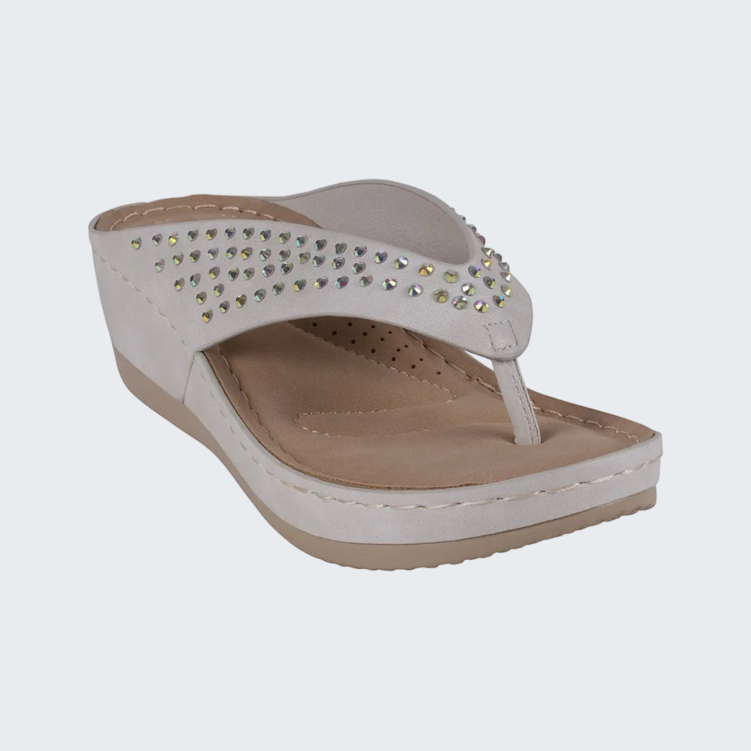 White sandal with rhinestone embellishments on a white background
