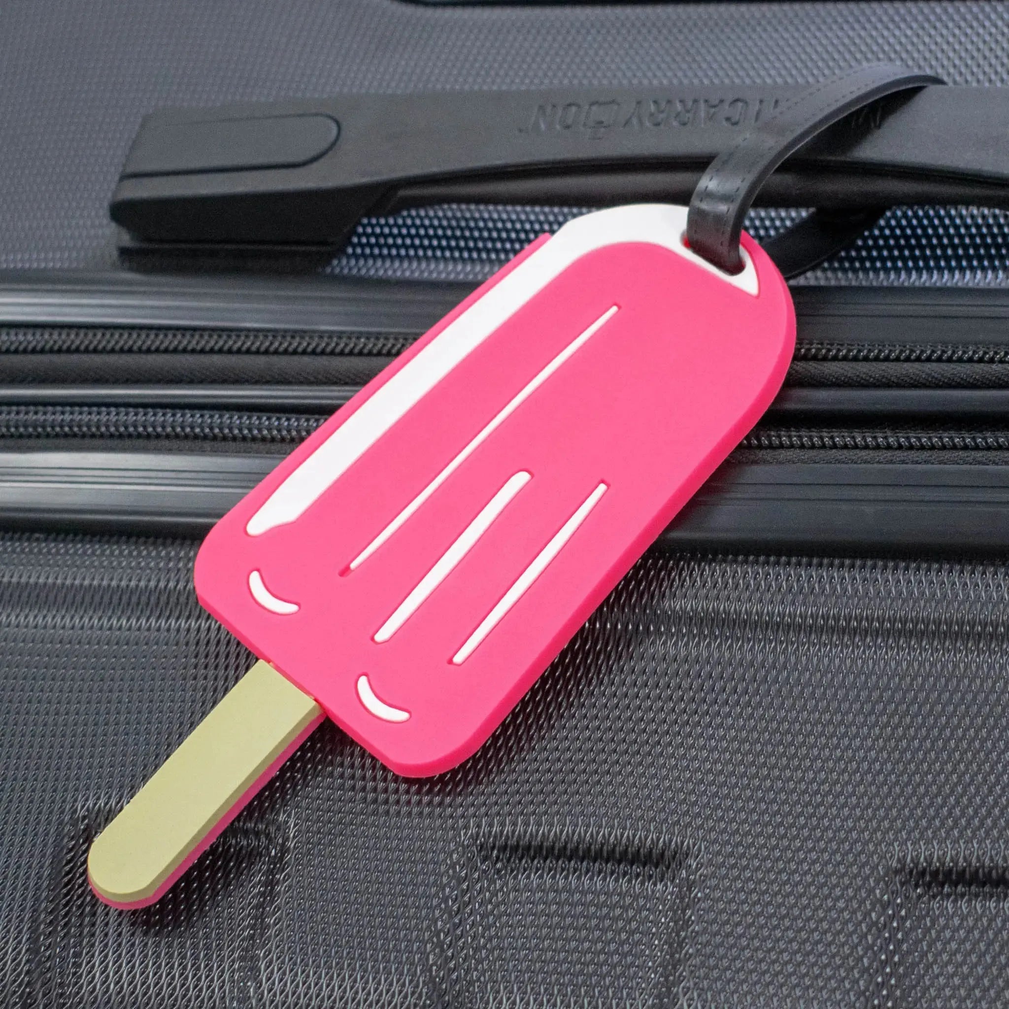 Pink popsicle-shaped luggage tag on a suitcase